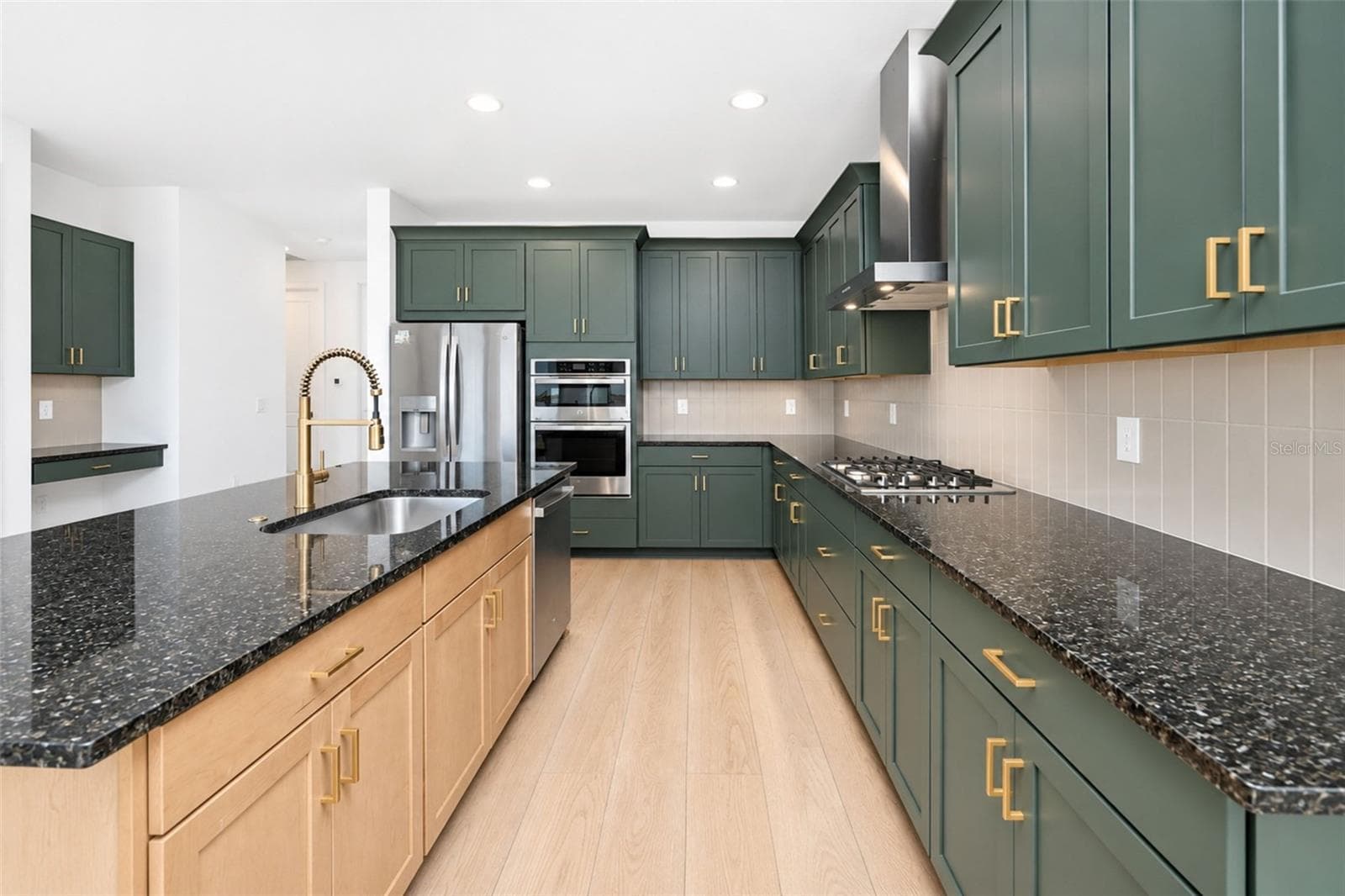 Showcasing custom green cabinetry accented by natural woodwork and elegant gold hardware. - 237 VISTERA BLVD, NOKOMIS