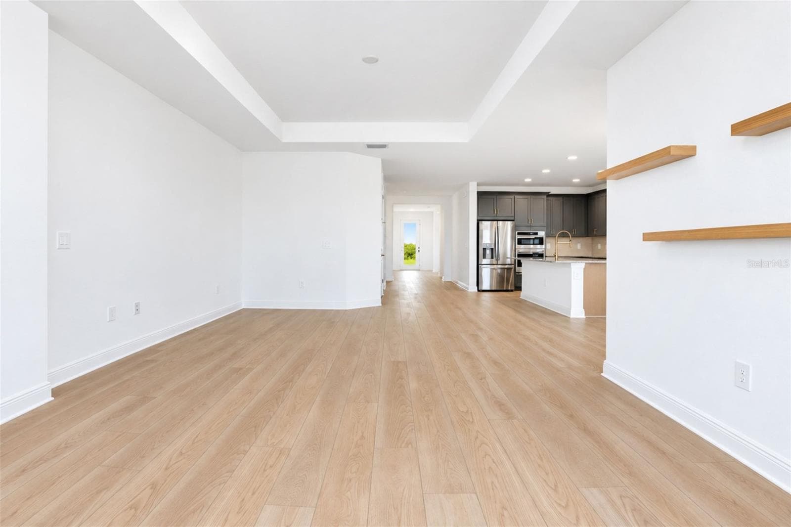 Spacious living room featuring an elegant tray ceiling and an open, airy design ideal for everyday living and entertaining. - 237 VISTERA BLVD, NOKOMIS