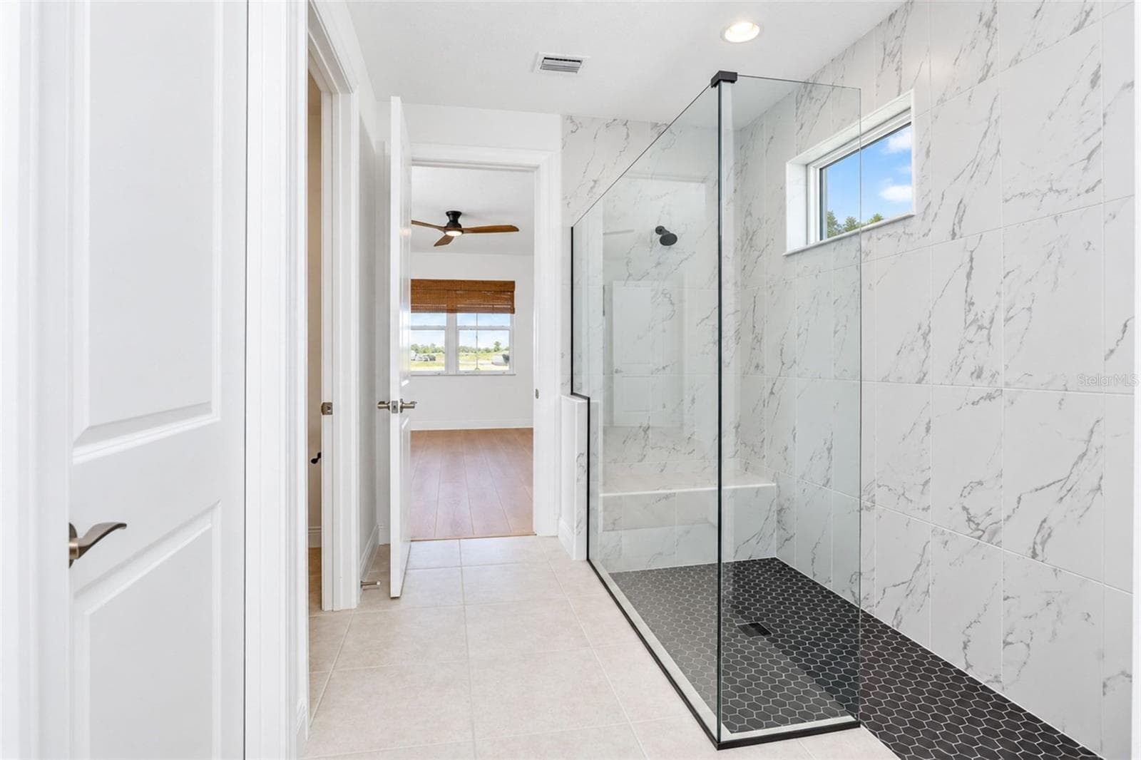 Spa-inspired primary bath with an expansive frameless walk-in shower and sleek modern finishes - 237 VISTERA BLVD, NOKOMIS