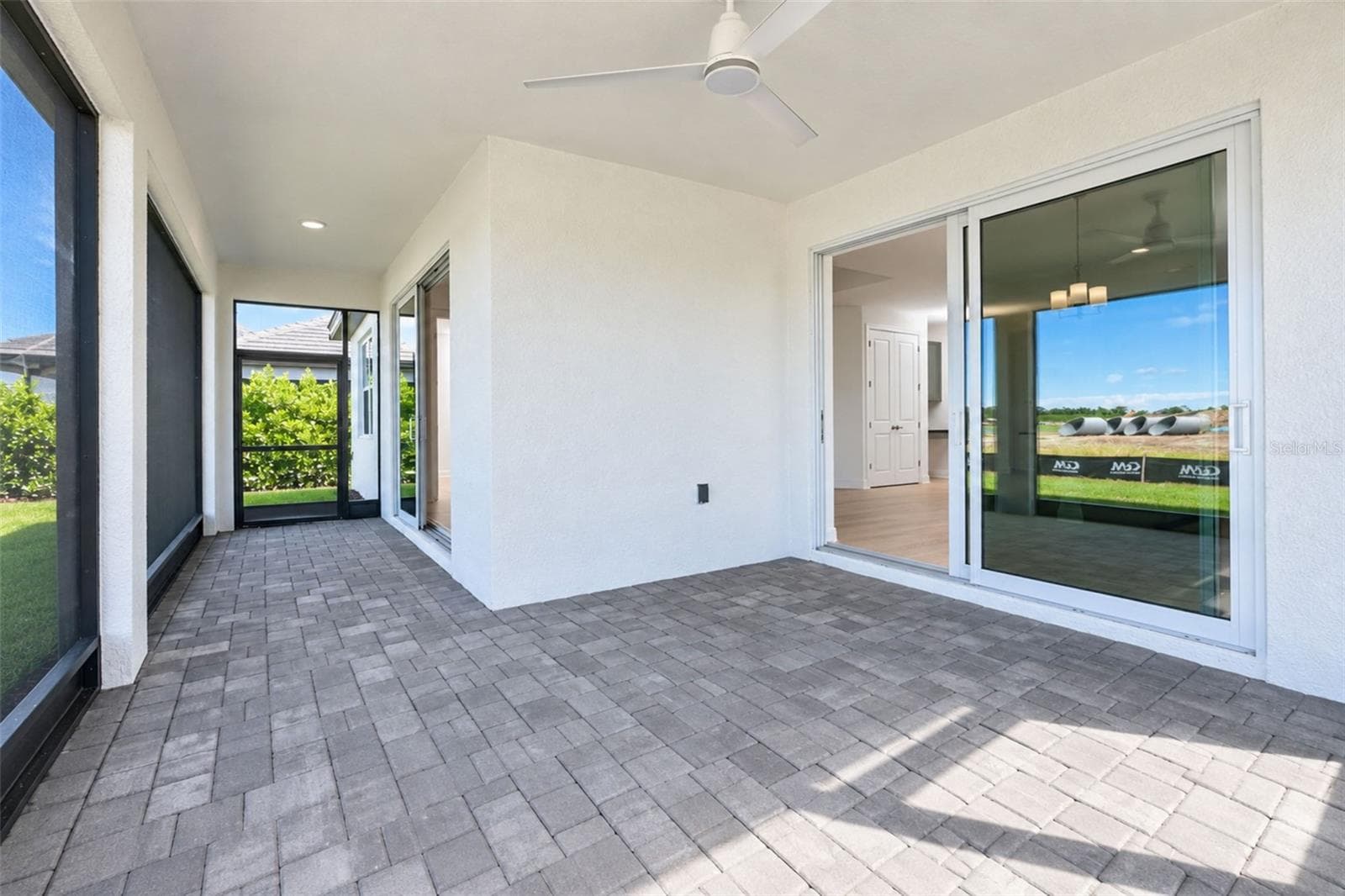 Oversized Screened Lanai – Expansive covered outdoor living space with paver flooring, ceiling fan and multiple sliding-glass-door access points. - 237 VISTERA BLVD, NOKOMIS