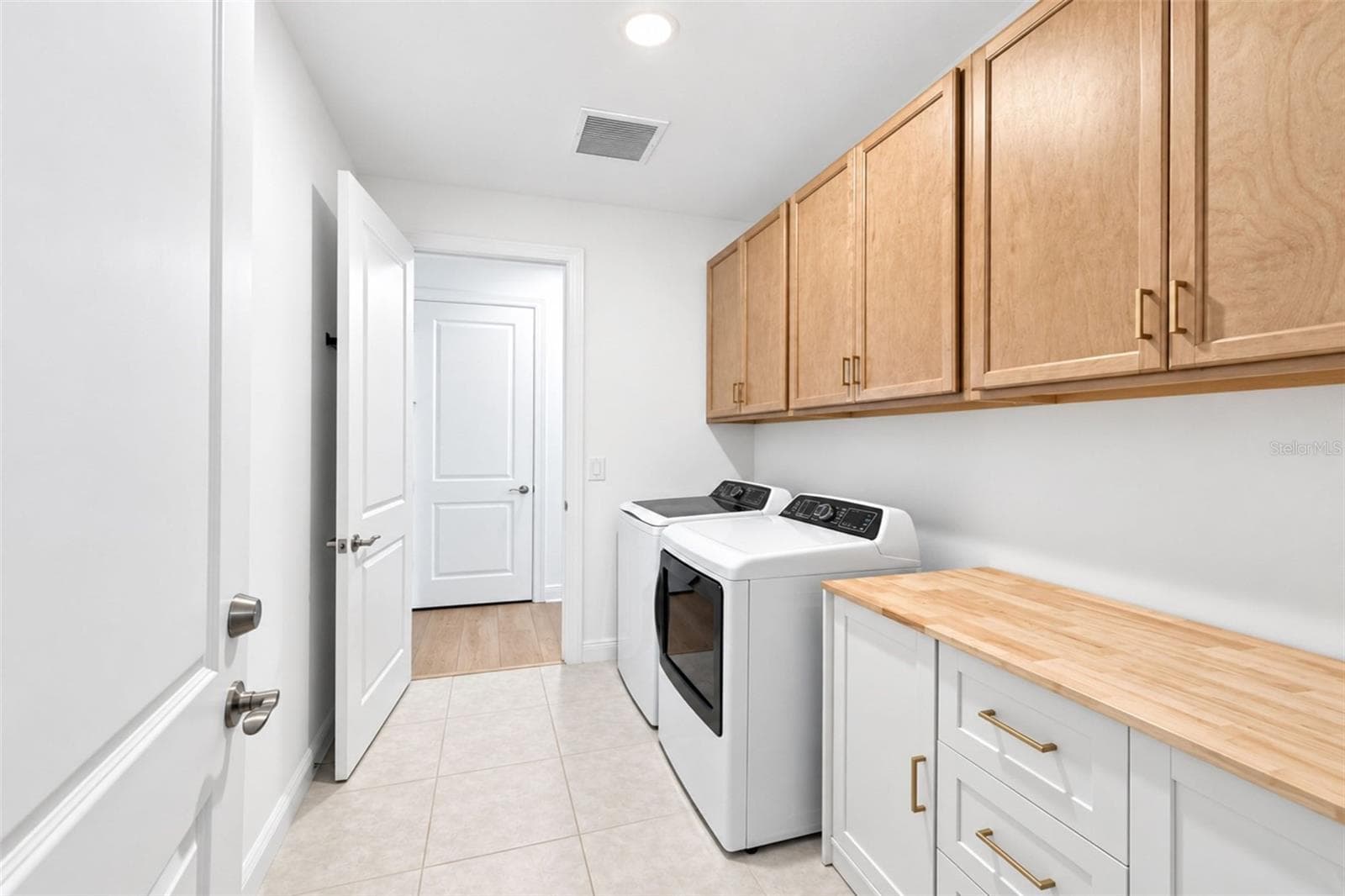 Thoughtfully designed laundry room featuring extensive cabinetry, GE profile washer & dryer additional storage and a butcher-block work surface. - 237 VISTERA BLVD, NOKOMIS