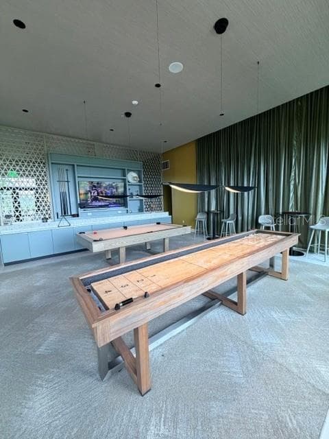 Stylish game room featuring shuffleboard, pool table, TV, and comfortable bar-style seating for gathering and entertaining. - 237 VISTERA BLVD, NOKOMIS