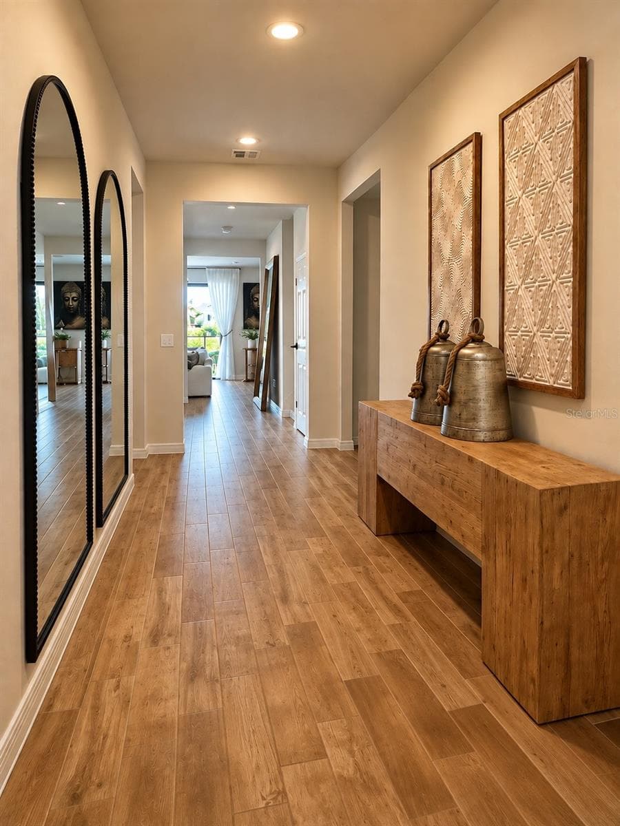 Welcoming foyer with warm wood-look flooring, recessed lighting, and a spacious hallway leading into the main living areas - 6735 REVERIE PARK AVE, ORLANDO