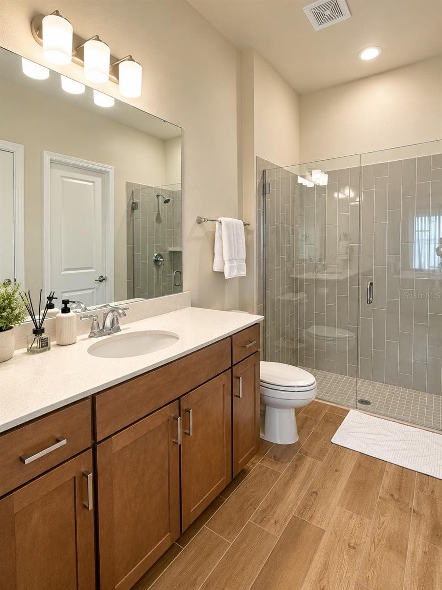 Guest Suite Bathroom – Private in-suite bathroom featuring a spacious walk-in shower with glass enclosure, modern vanity, and contemporary finishes. - 6735 REVERIE PARK AVE, ORLANDO