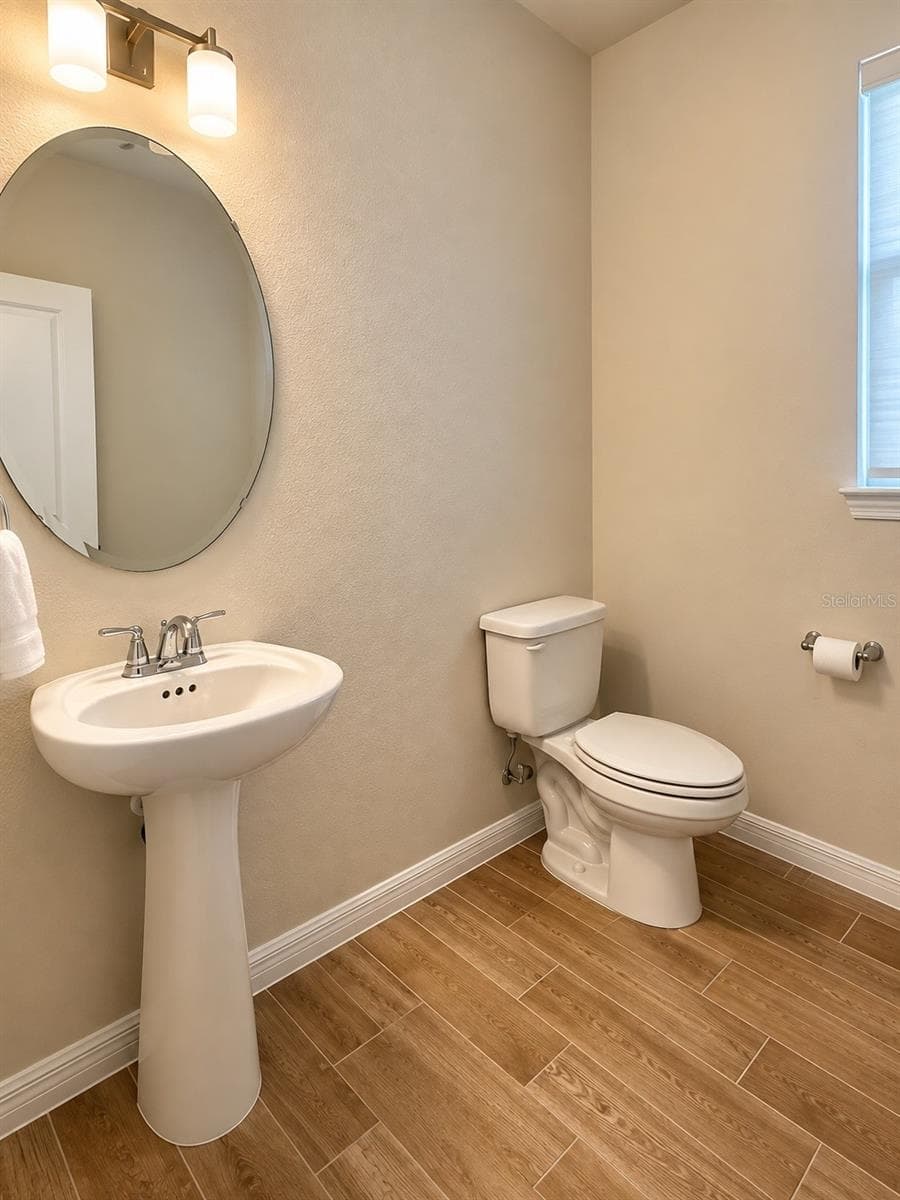 Guest Half Bathroom with pedestal sink and modern finishes. - 6735 REVERIE PARK AVE, ORLANDO