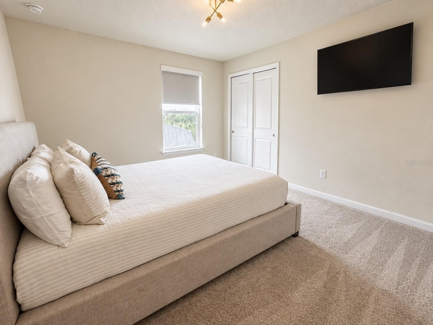 Bright and spacious fourth bedroom featuring abundant natural light, neutral finishes, plush carpeting, generous closet space, and a comfortable layout ideal for family or guests. - 6735 REVERIE PARK AVE, ORLANDO