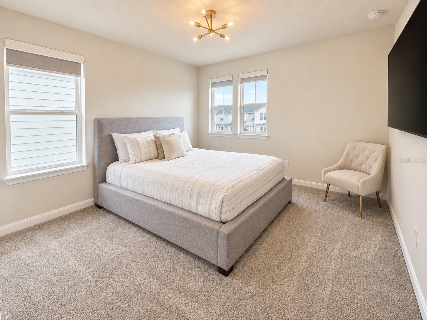 Bright and spacious fifth bedroom featuring multiple windows for abundant natural light, neutral finishes, plush carpeting, generous closet space, and a comfortable layout ideal for family or guests - 6735 REVERIE PARK AVE, ORLANDO