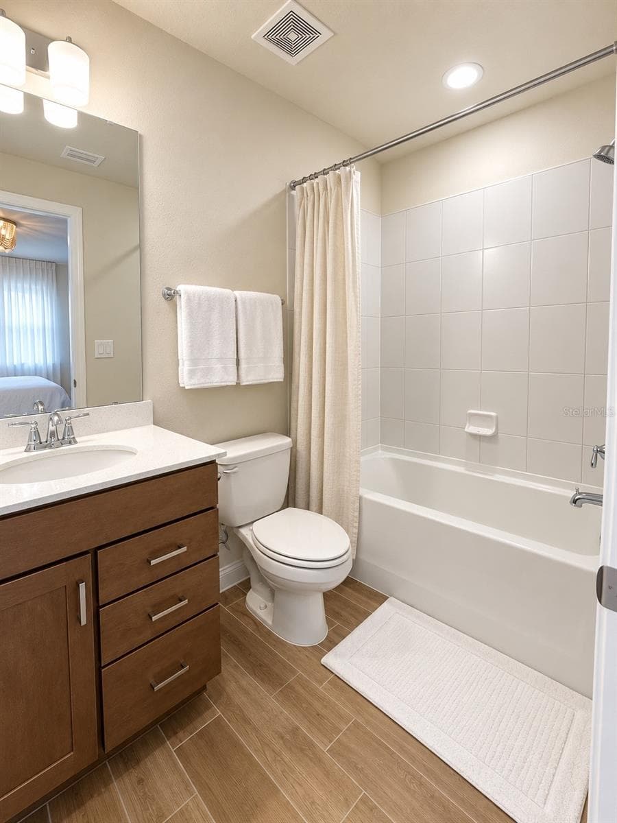 Fourth full bathroom conveniently shared by Bedrooms 4 and 5, featuring a tub/shower combination, modern vanity, tile flooring, and a clean, functional design. - 6735 REVERIE PARK AVE, ORLANDO