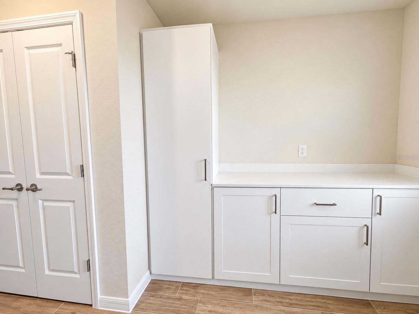 Spacious and functional laundry room with  ample built-in cabinetry, generous countertop workspace, and additional storage. - 6735 REVERIE PARK AVE, ORLANDO