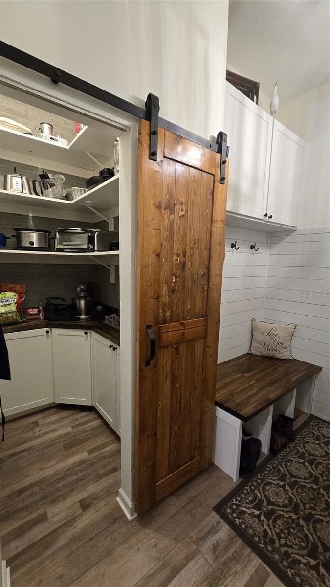 Large Laundry Room with a walk in storage room with additional cabinets.  Plus a sitting bench and wash sink. - 9991 WINDTREE BLVD, SEMINOLE