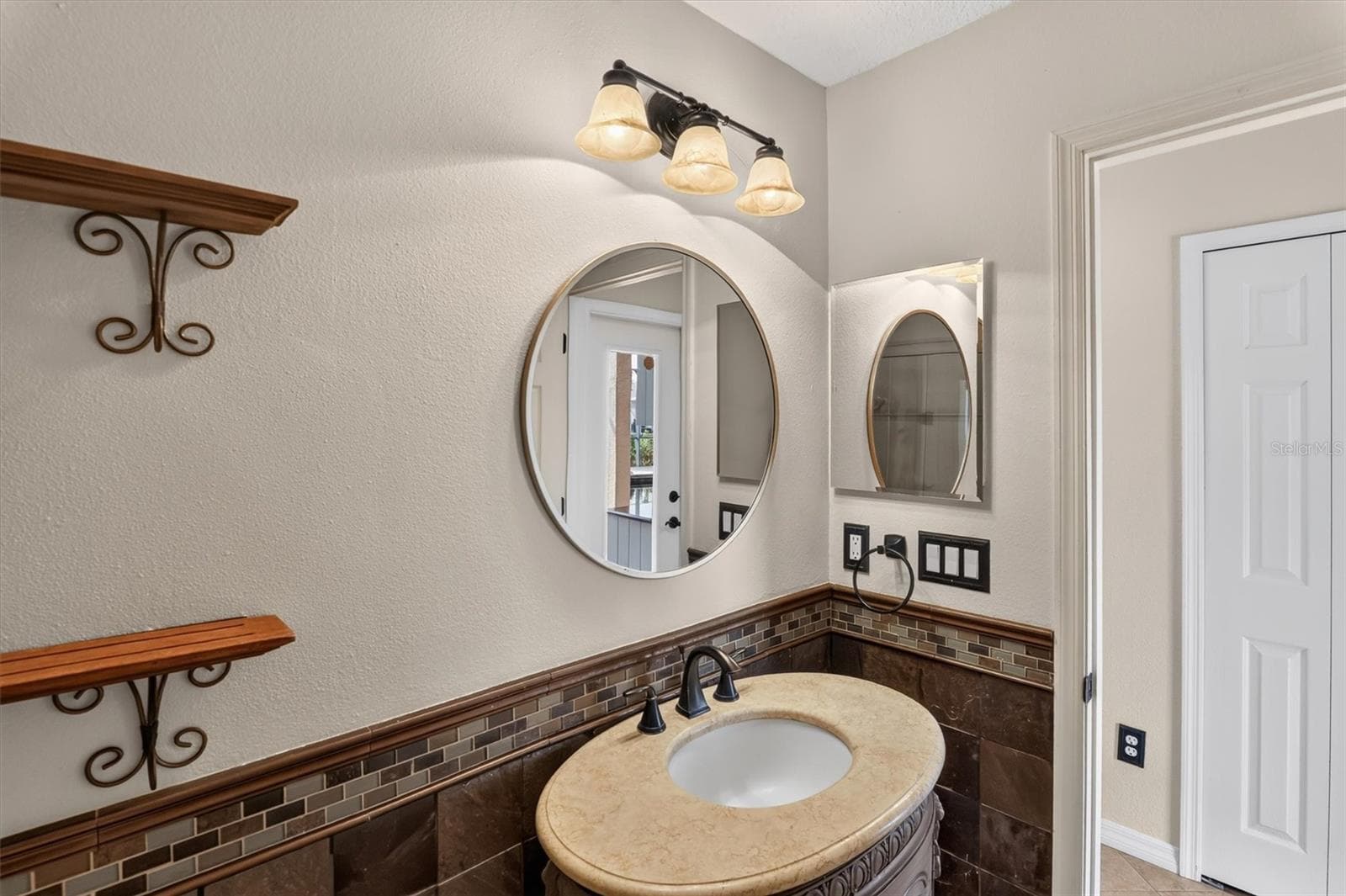 1st floor Bathroom with a round mirror and vanity. - 2109 WEMBLEY PL, OVIEDO