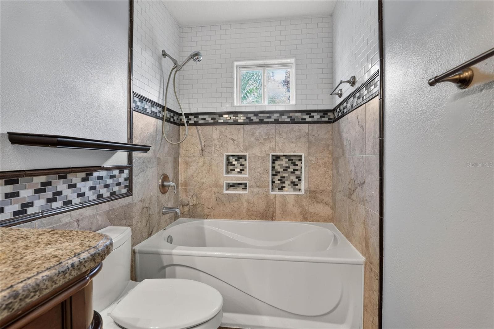 Tub-shower area with decorative tile and a window. - 2109 WEMBLEY PL, OVIEDO