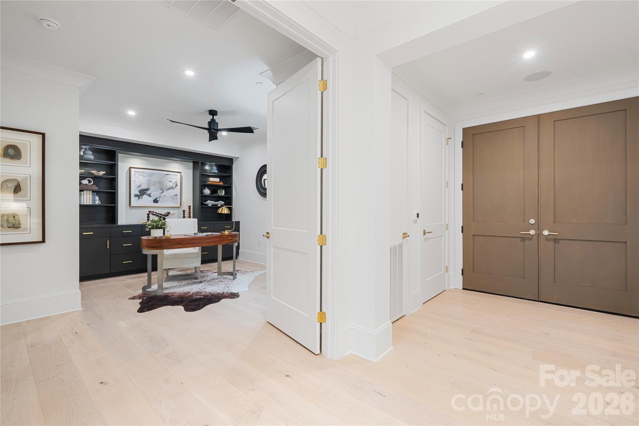 Just off the entry, the sophisticated office with custom cabinetry provides views across the Great Room and beyond, or can be closed-off for maximum privacy. - 409 Queens Road, Charlotte