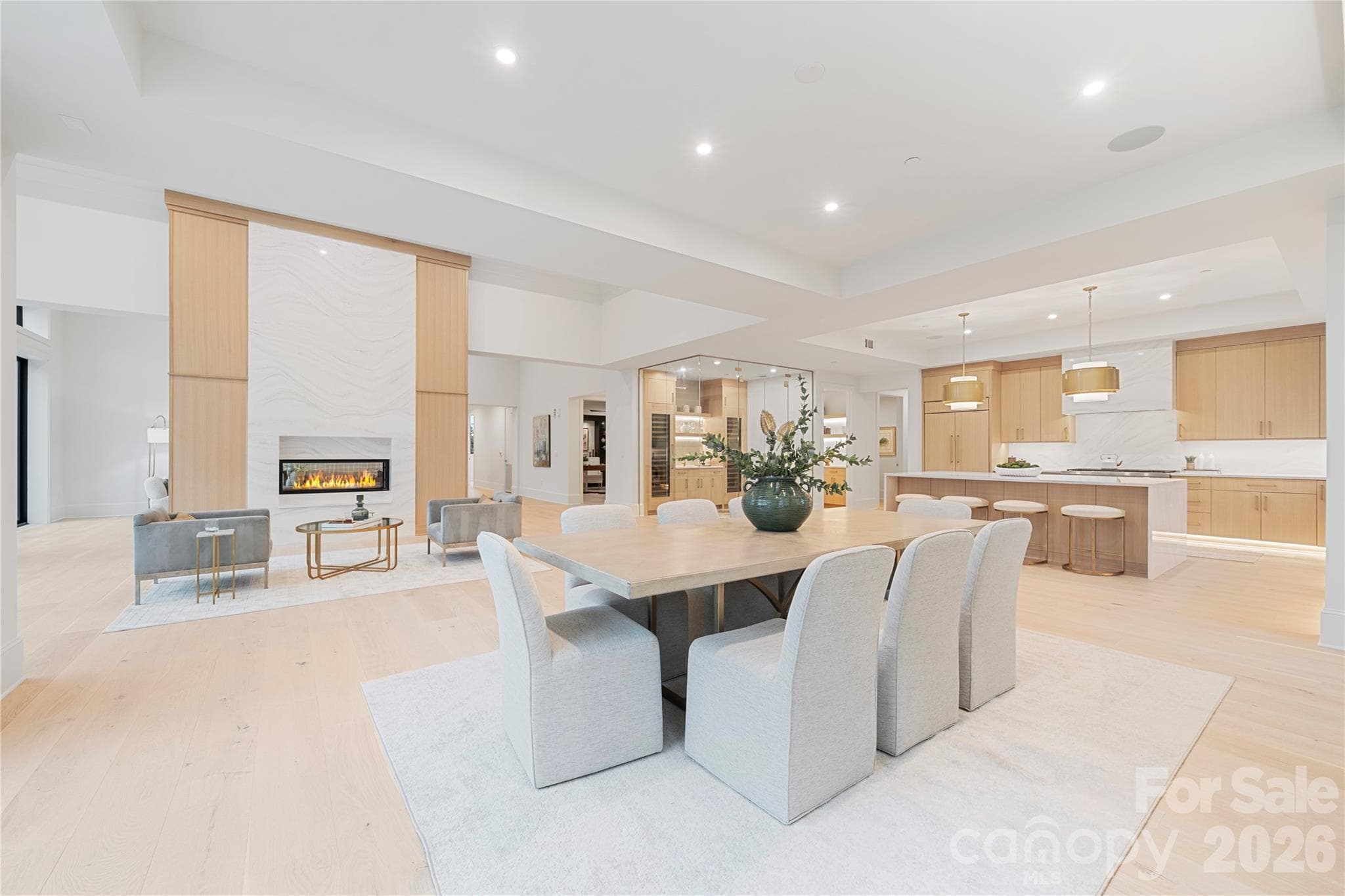 A sweeping view of the dining room, gourmet kitchen and statement fireplace highlights the home’s exceptional scale and open-concept design. - 409 Queens Road, Charlotte