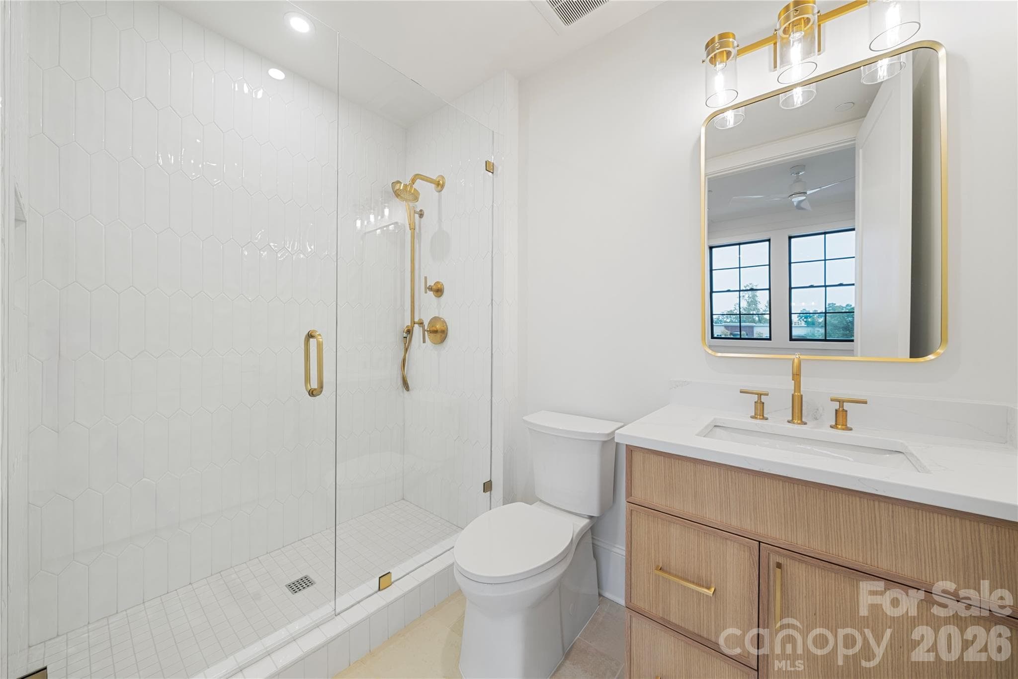 Part of the Bedroom 2 suite, this bathroom provides a contemporary retreat with a large glass-enclosed shower and custom vanity. - 409 Queens Road, Charlotte
