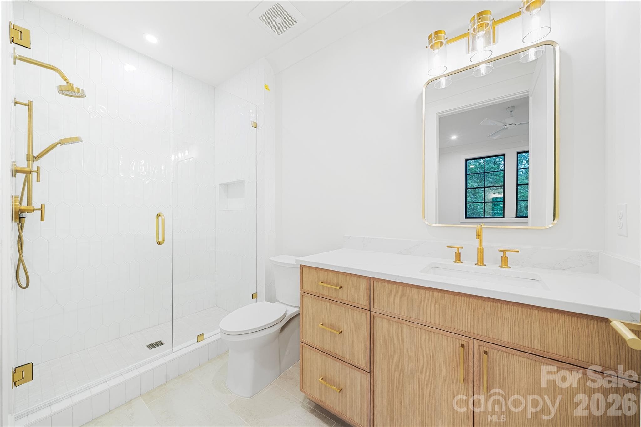 The bright full bath with a glass-enclosed shower and custom cabinetry of bedroom 3. - 409 Queens Road, Charlotte