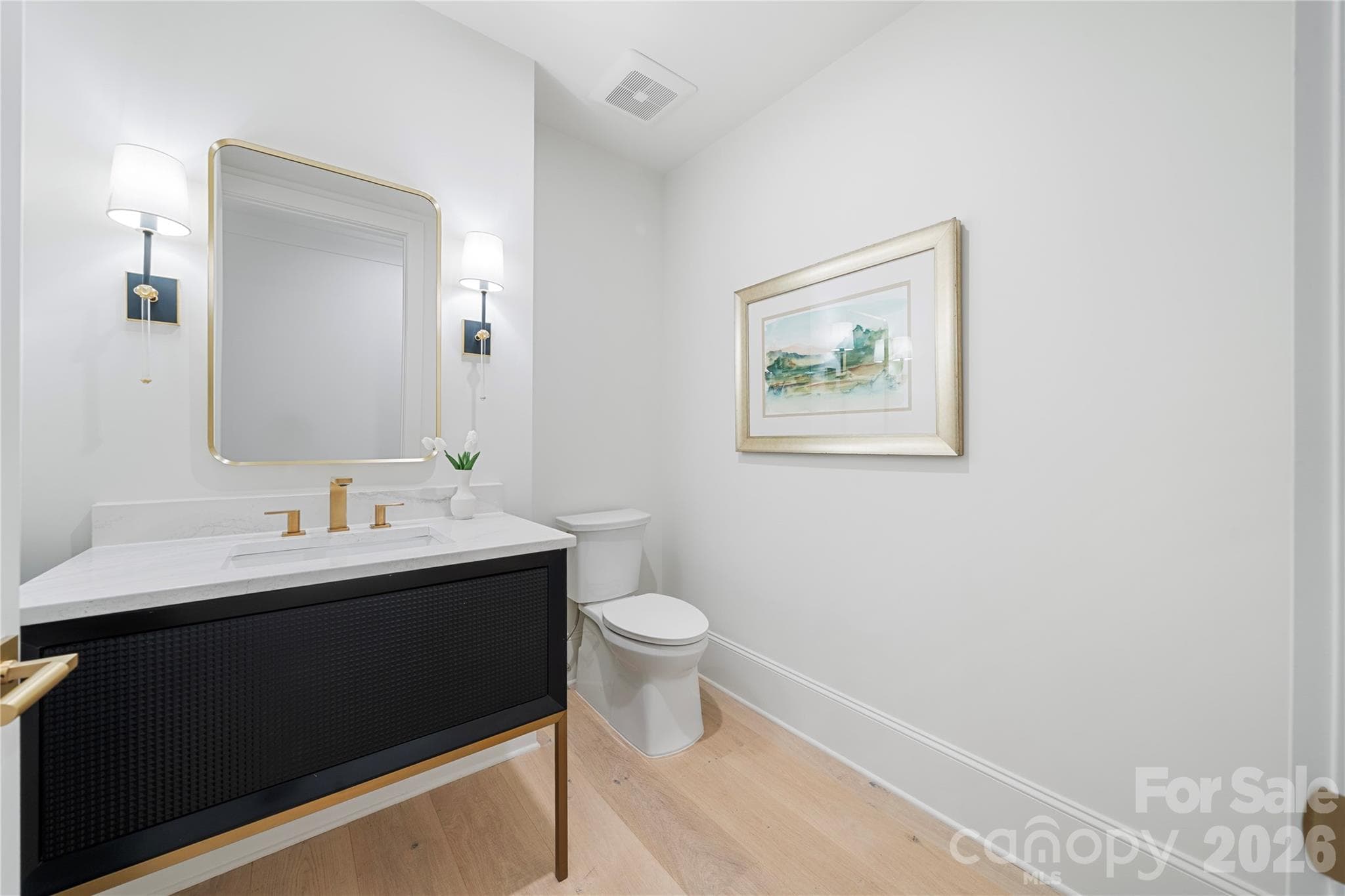 The contemporary powder room with distinctive dark vanity and marble countertop presents an elegant and contemporary aspect. - 409 Queens Road, Charlotte