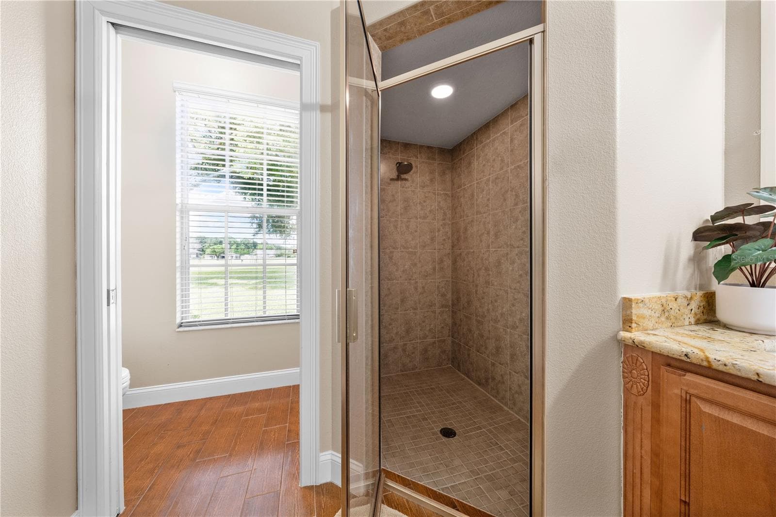 Primary Bathroom has a shower with rain-style showerhead and private door for the toilet. - 4349 PACKARD AVE, ST CLOUD