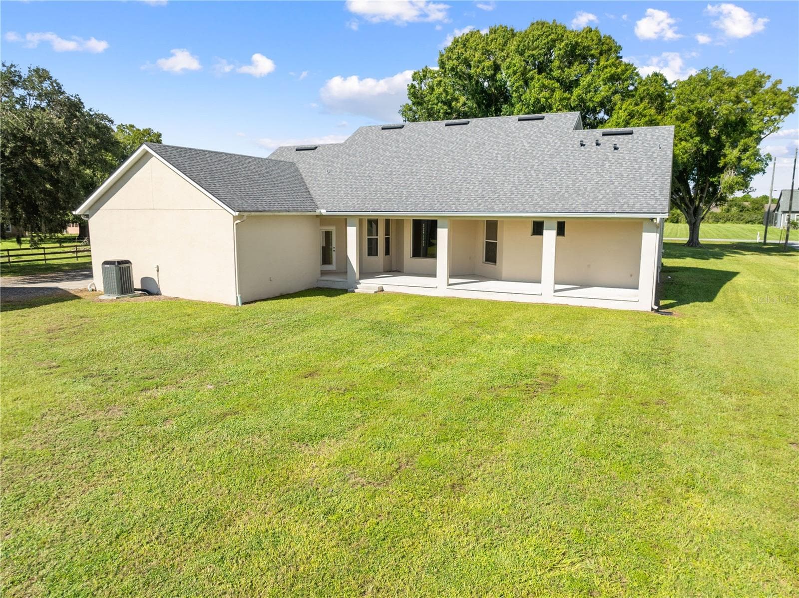 Exterior of the home with the covered back porch, plenty of space for a pool. - 4349 PACKARD AVE, ST CLOUD