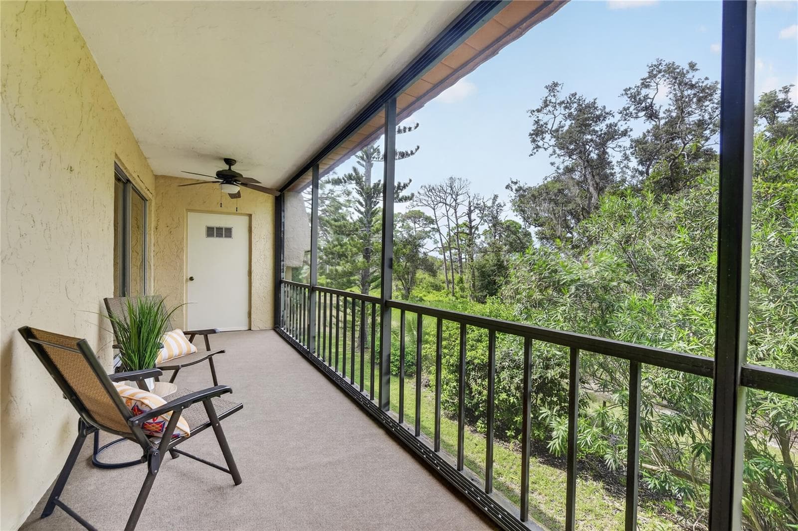 Large screened backdoor lanai with a view of the Oscar Scherer State Park - 203 RUBENS DR #F, NOKOMIS
