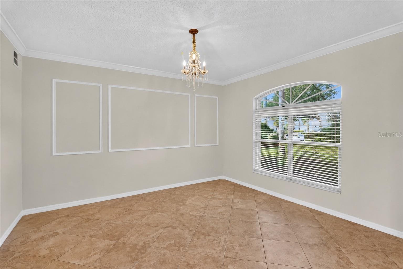 Not staged: Sitting room with decorative wall molding and an arched window. - 2109 WEMBLEY PL, OVIEDO