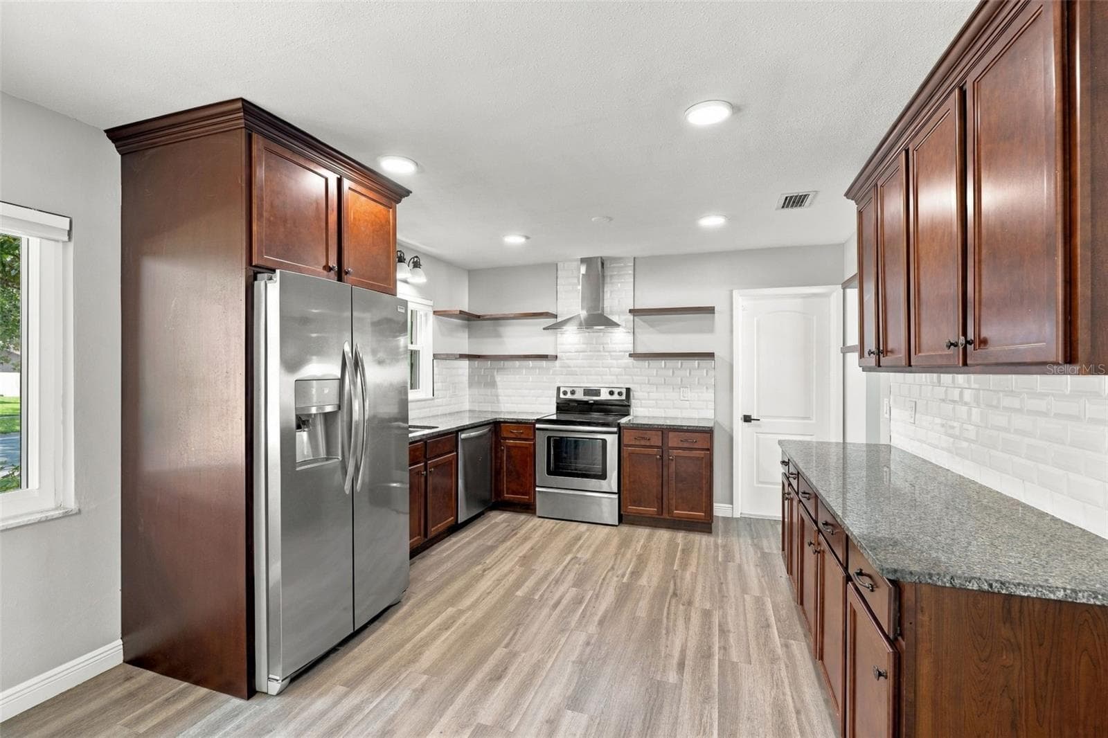 Granite counters, stainless steel appliances and a vented hood above the range give this kitchen a contemporary look and feel with excellent functionality. - 2260 SAINT CHARLES DR, CLEARWATER