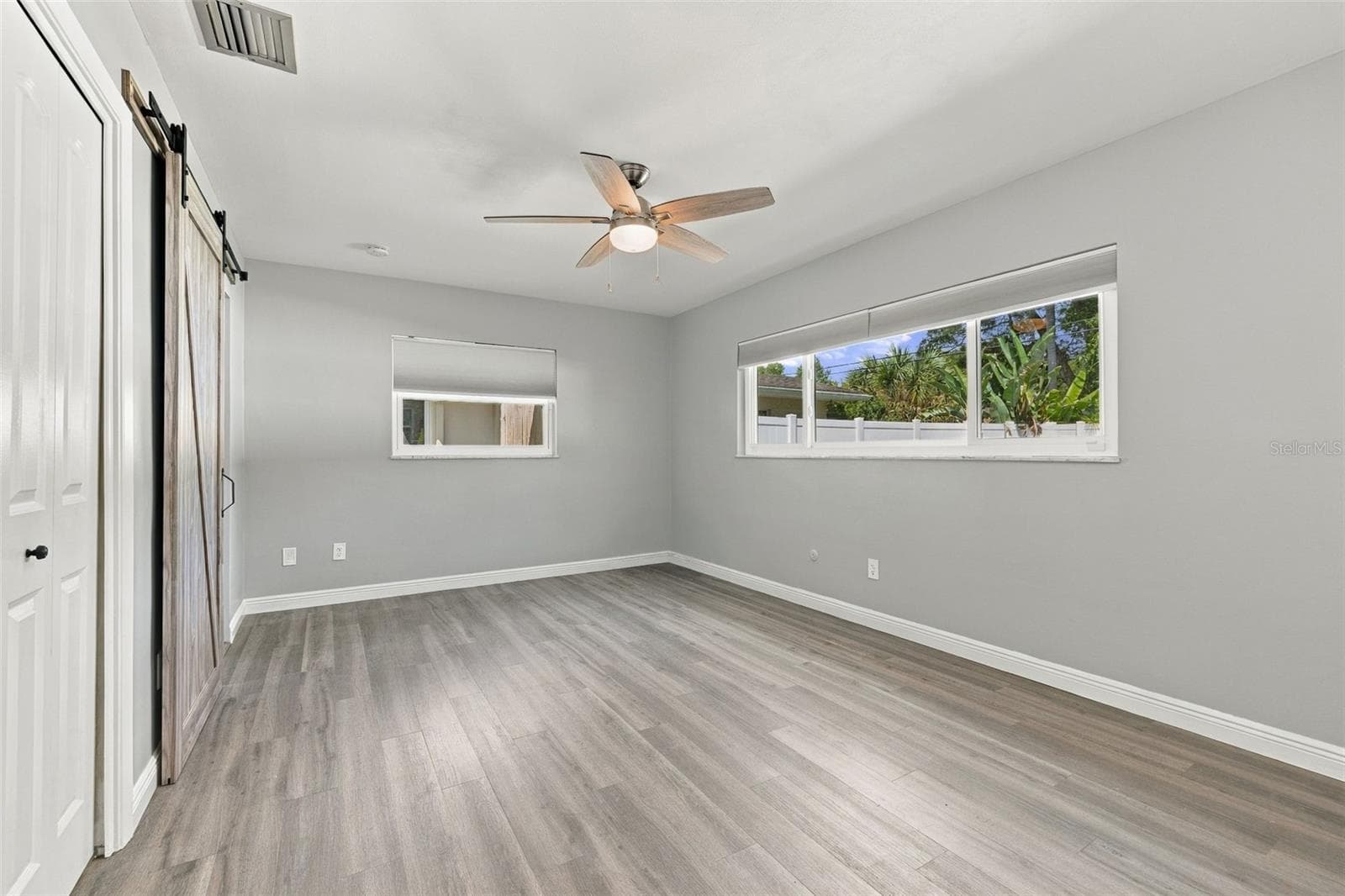 The primary bedroom has a walk-in closet and barn door to the ensuite bathroom. - 2260 SAINT CHARLES DR, CLEARWATER