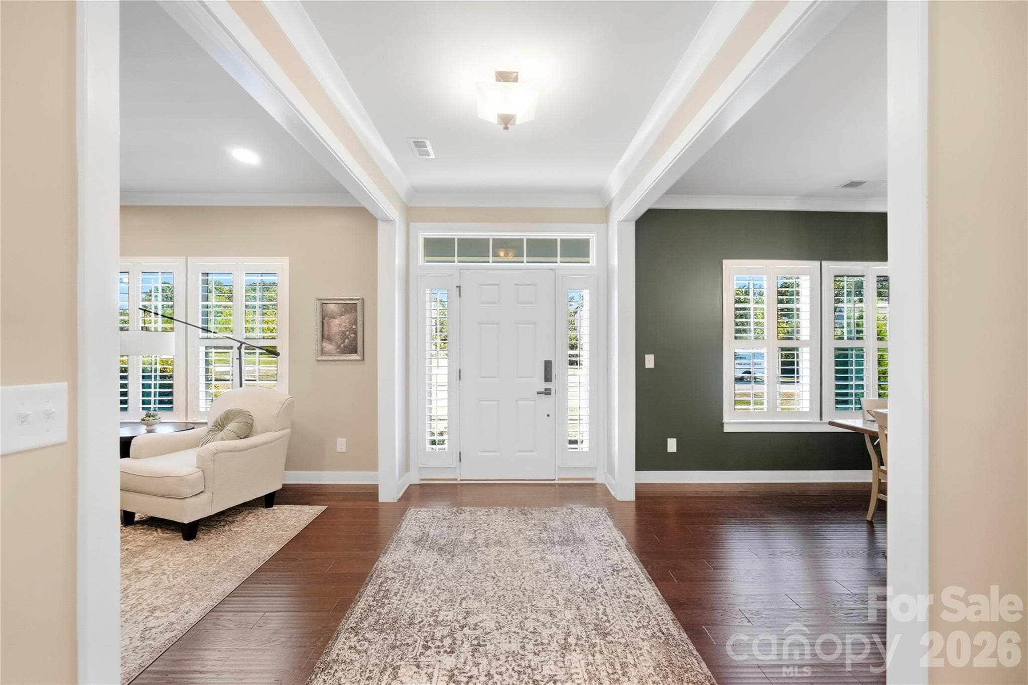 Welcoming foyer with hardwood floors, crown molding, and wide cased openings to the dining room and den/second office. - 912 Manorwood Drive, Waxhaw