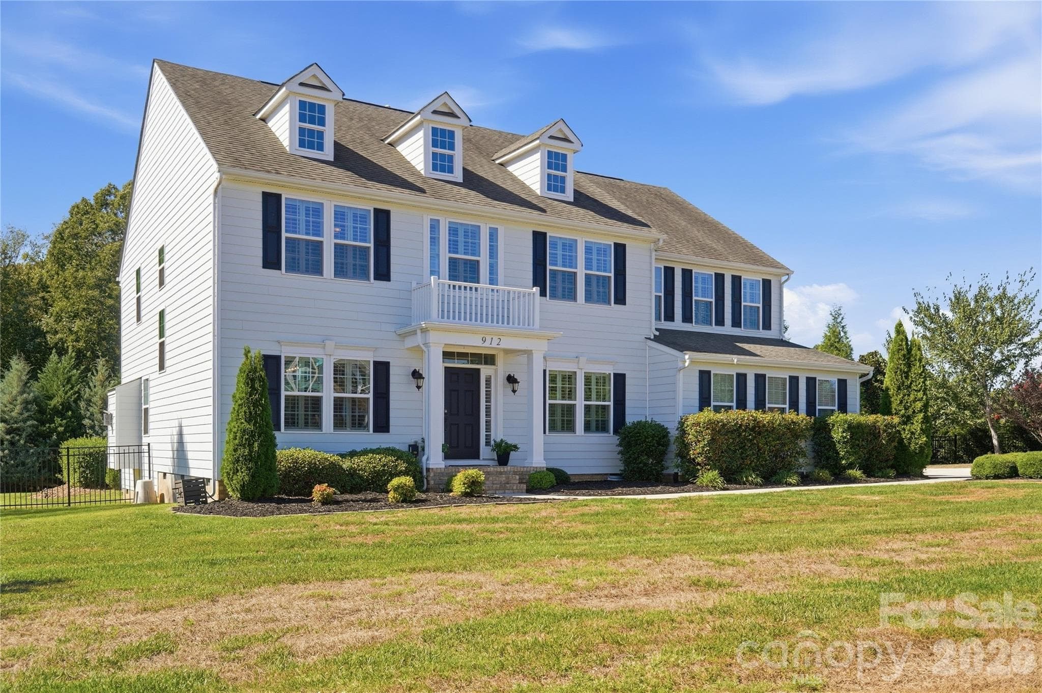 Georgian Colonial with a columned front portico and mature landscaping, set on 0.94 acres at the end of a quiet cul-de-sac. - 912 Manorwood Drive, Waxhaw