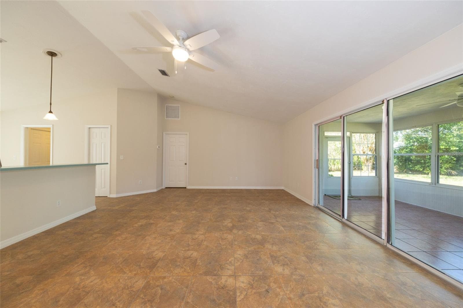 large living room, looking towards primary bedroom. kitchen to the left, Florida room to the right. - 141 BREN MAR LN, PALM COAST