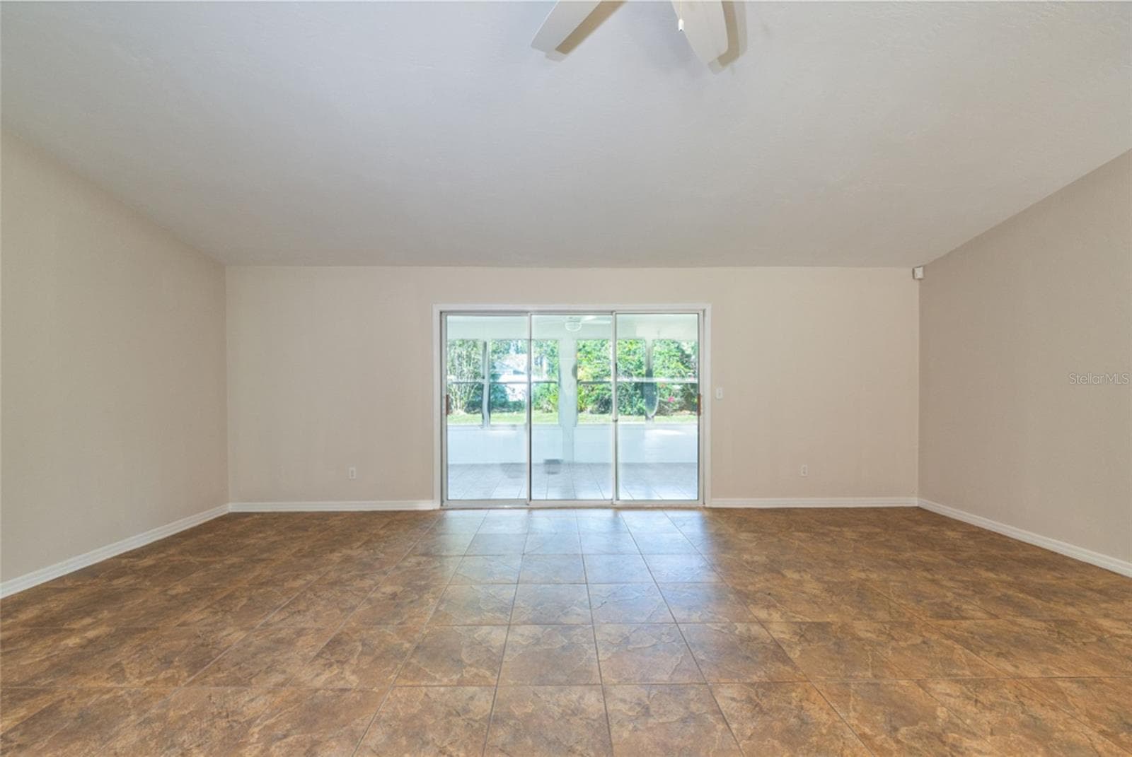 Living room looking towards the 200 sf Florida room. Triple sliders let in so much natural light. - 141 BREN MAR LN, PALM COAST