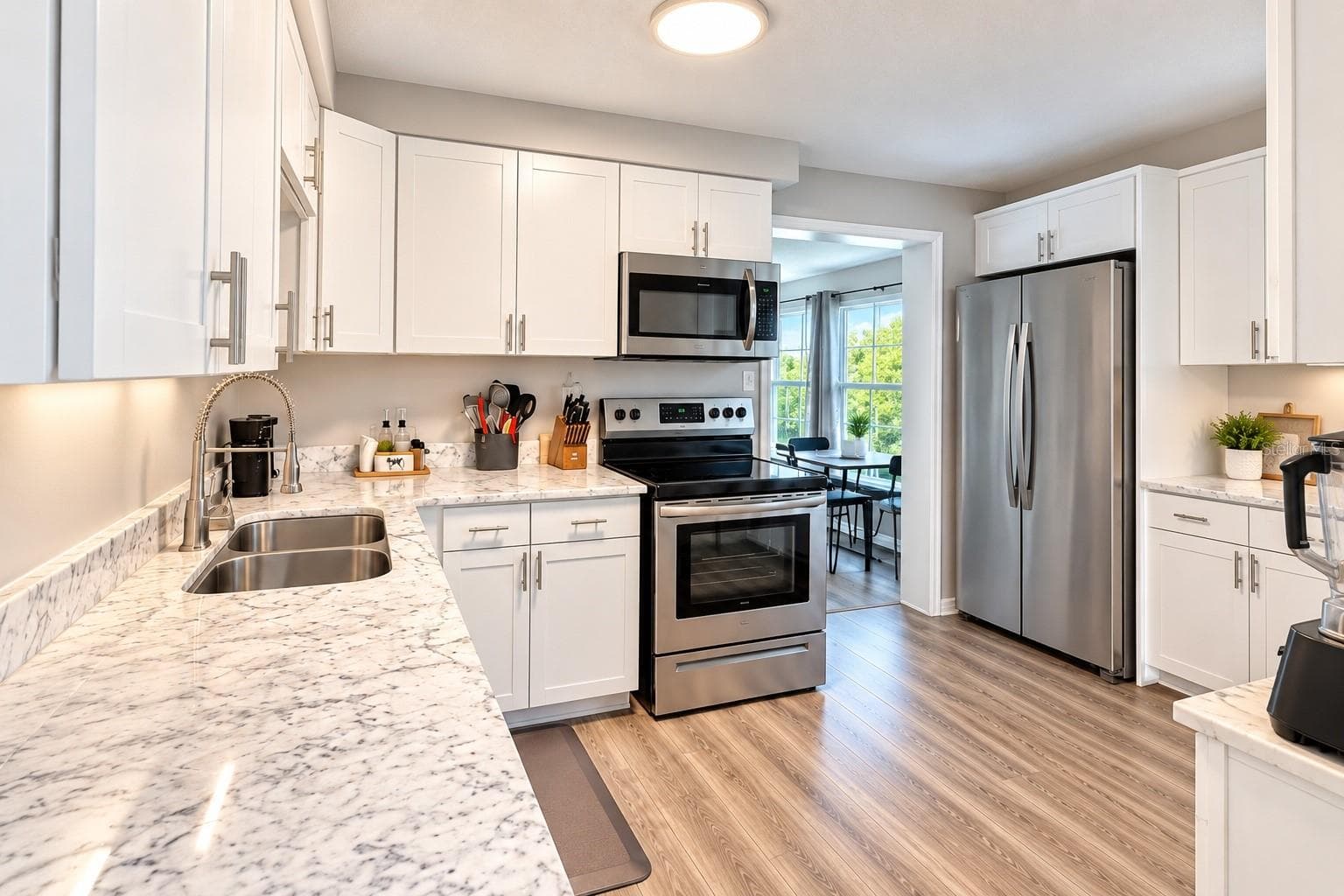 Updated kitchen with white shaker-style cabinetry and granite countertops. - 8514 93RD AVE, SEMINOLE