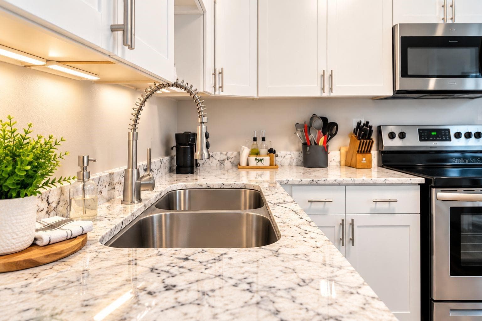 Close-up of the kitchen’s granite surfaces and updated fixtures. - 8514 93RD AVE, SEMINOLE