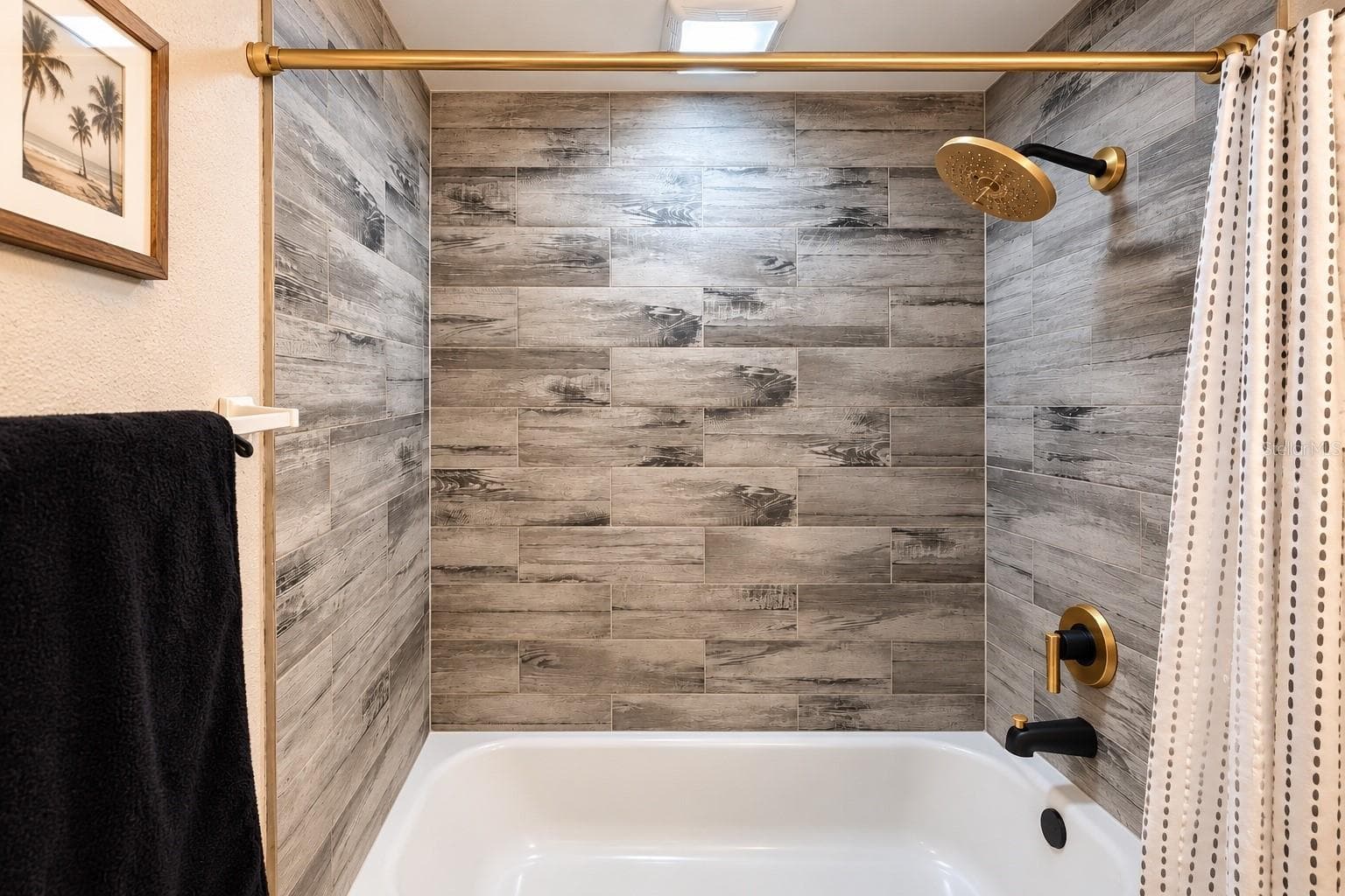 Updated bath with contemporary finishes and coordinated black-and-gold hardware. - 8514 93RD AVE, SEMINOLE