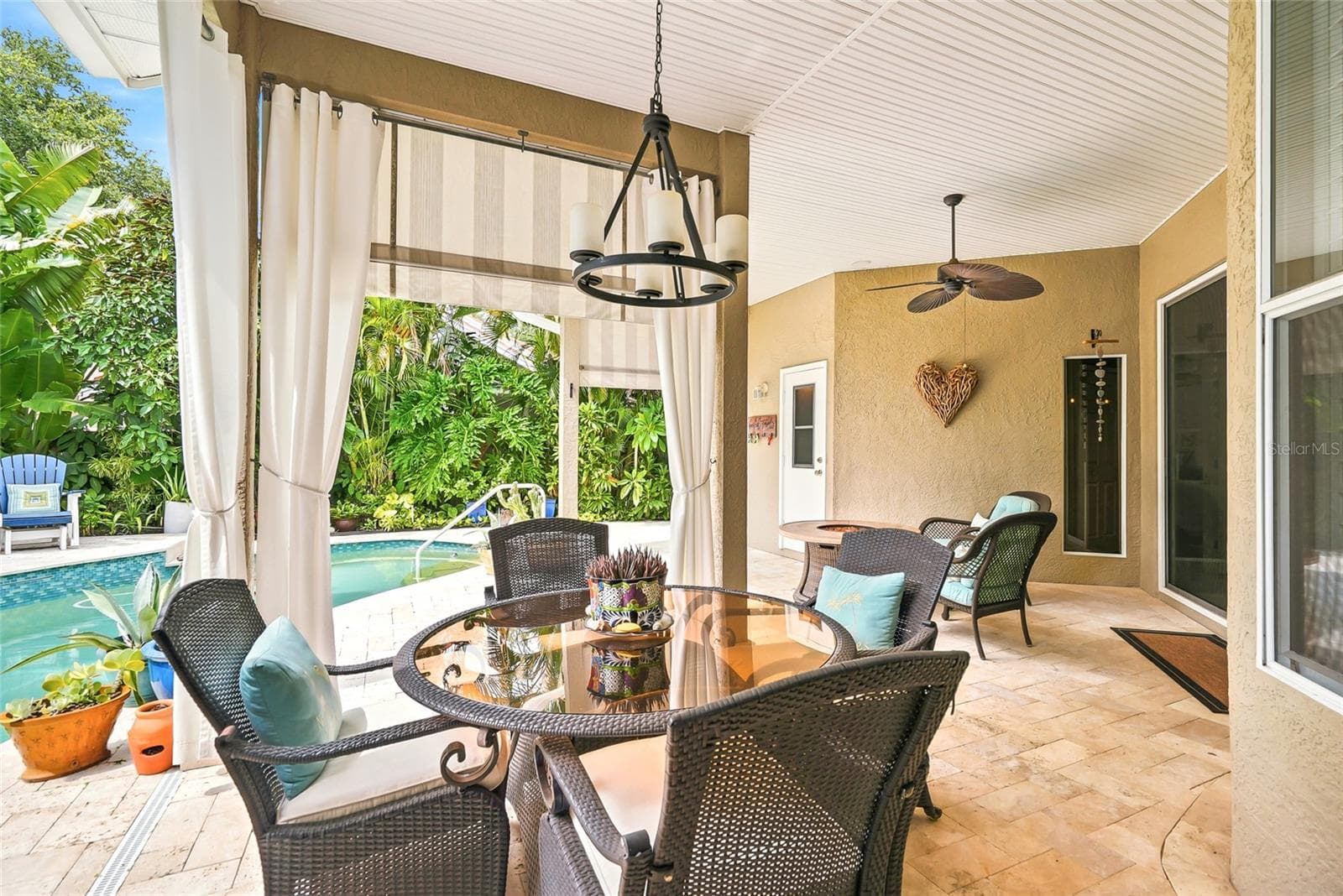 Cabana-style curtains frame the covered patio peering to the pool. - 4851 WINDMILL PALM TER NE, ST PETERSBURG