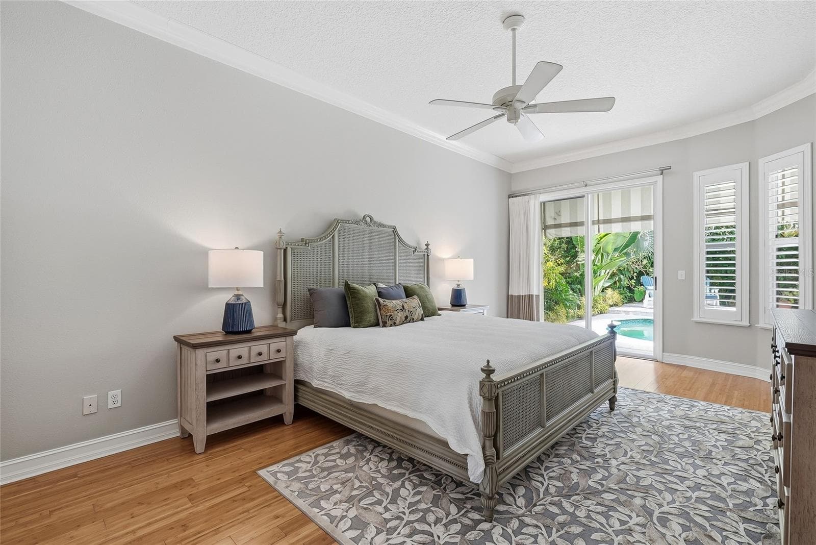Oversized primary bedroom with a glimmering view of the pool. - 4851 WINDMILL PALM TER NE, ST PETERSBURG