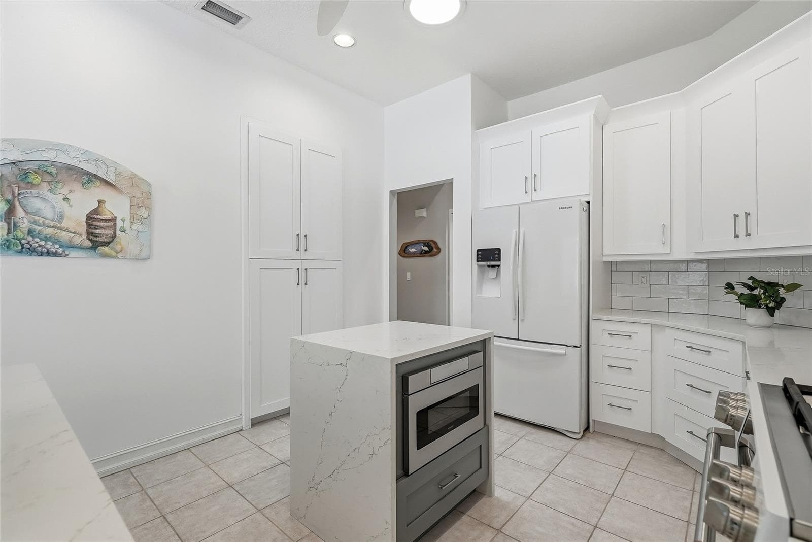 Discreet microwave in the kitchen island keeps the streamlined look of the kitchen. - 4851 WINDMILL PALM TER NE, ST PETERSBURG