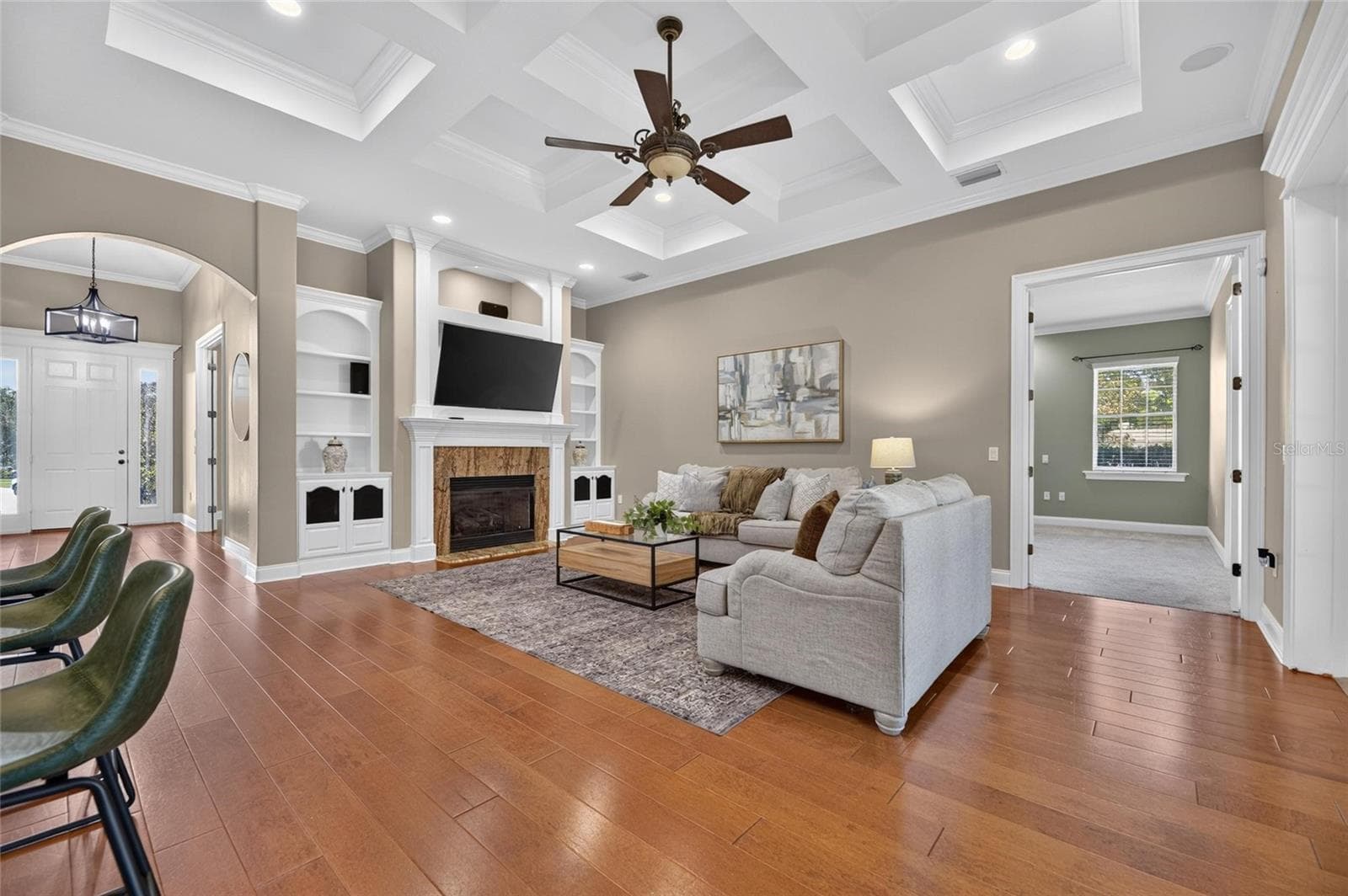 Stunning Living room with tray ceiling, gas fireplace, custom built in and beautiful hardwood flooring - 6408 WALKERS GLEN DR, LAKELAND