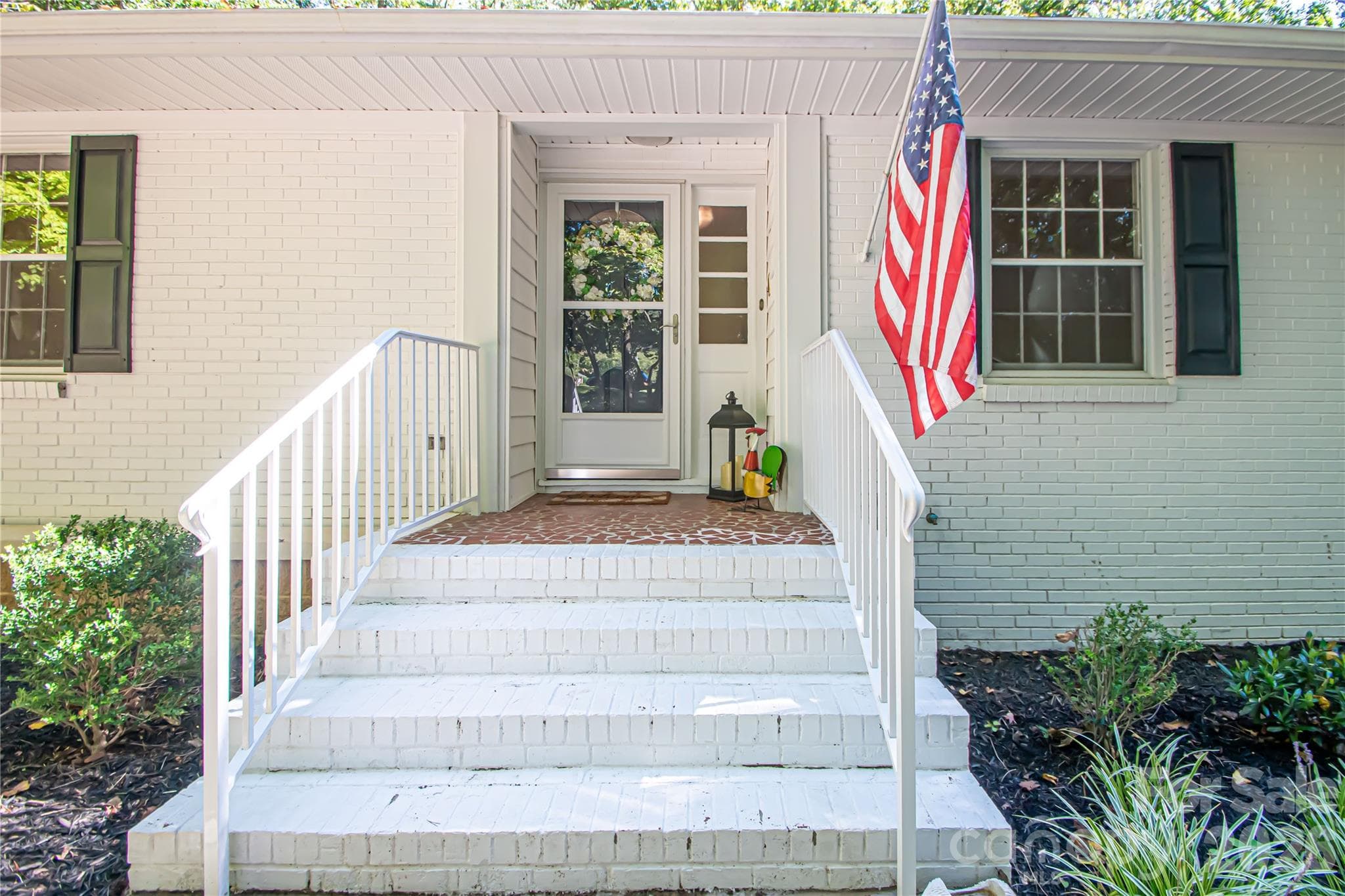Full brick home with a small section of vinyl siding by the sunroom. - 7400 Oakwood Lane, Charlotte