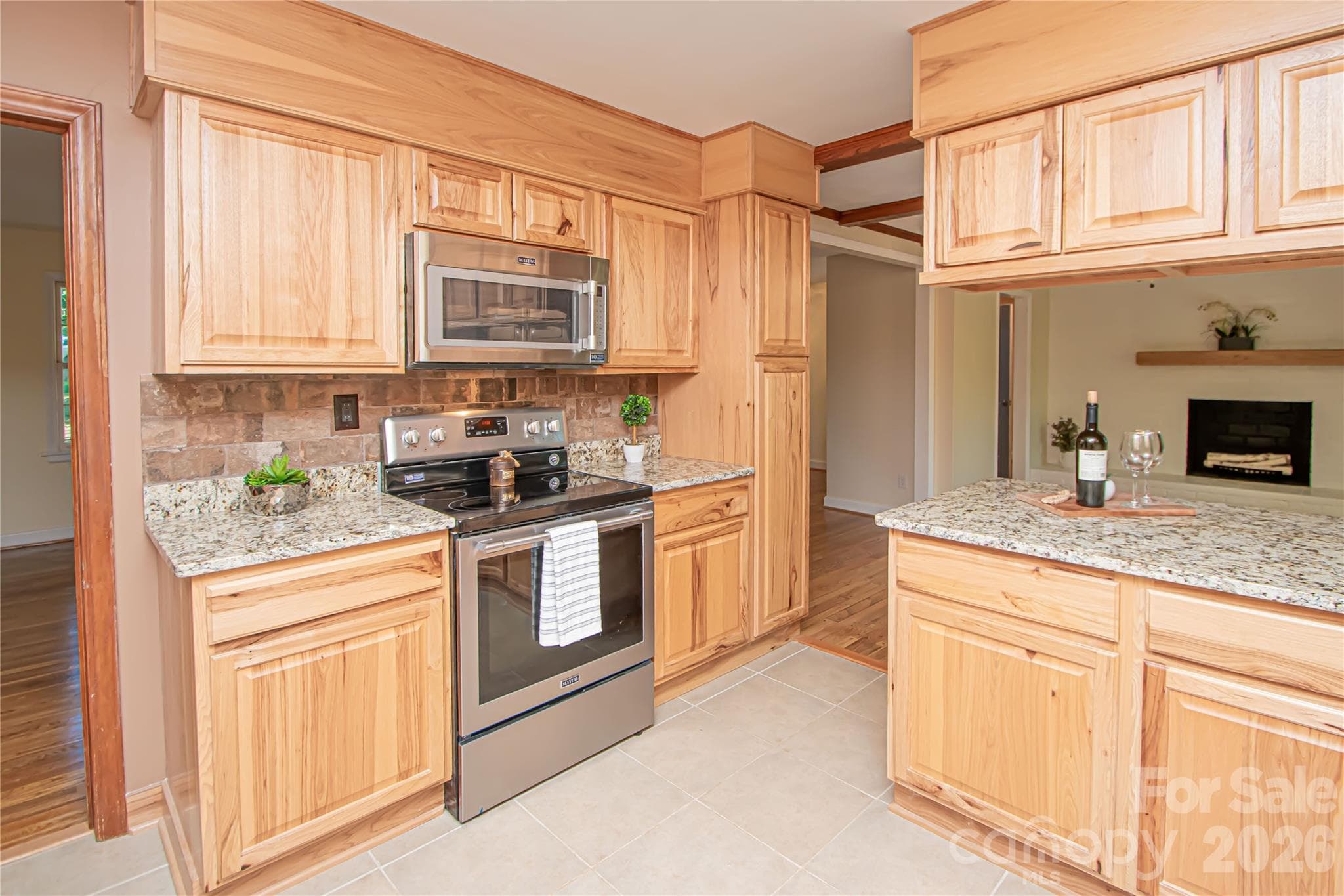 Kitchen was updated a few years ago with stainless steel appliances, new cabinets, tile backsplash, tile floor and granite countertops. - 7400 Oakwood Lane, Charlotte