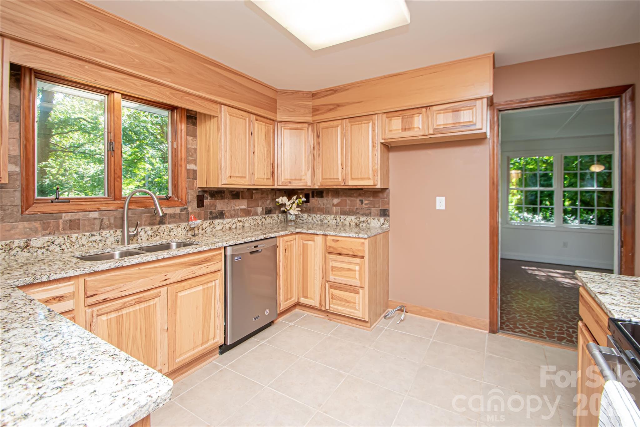 Kitchen was updated a few years ago with stainless steel appliances, new cabinets, tile backsplash, tile floor and granite countertops. - 7400 Oakwood Lane, Charlotte