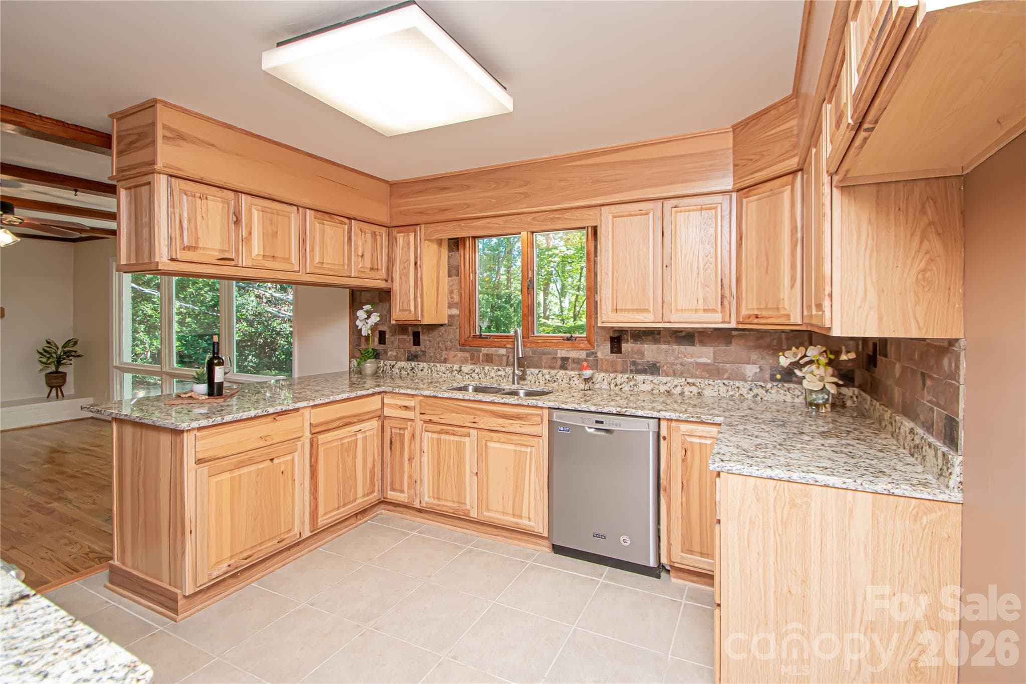 Kitchen was updated a few years ago with stainless steel appliances, new cabinets, tile backsplash, tile floor and granite countertops. - 7400 Oakwood Lane, Charlotte