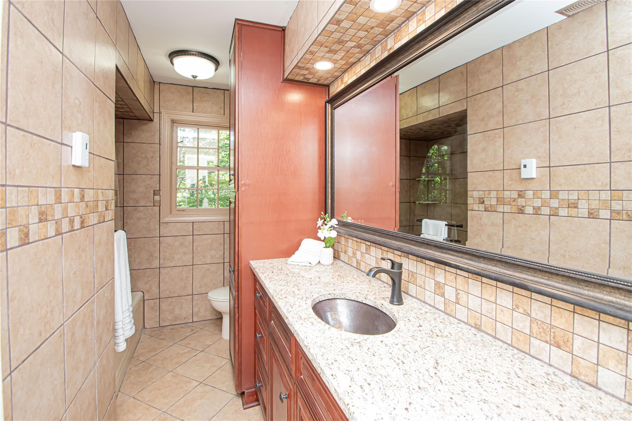 Hall bath on main level was updated a few years ago with granite countertop, all over tile, vanity, faucet, sink and glass shower. - 7400 Oakwood Lane, Charlotte