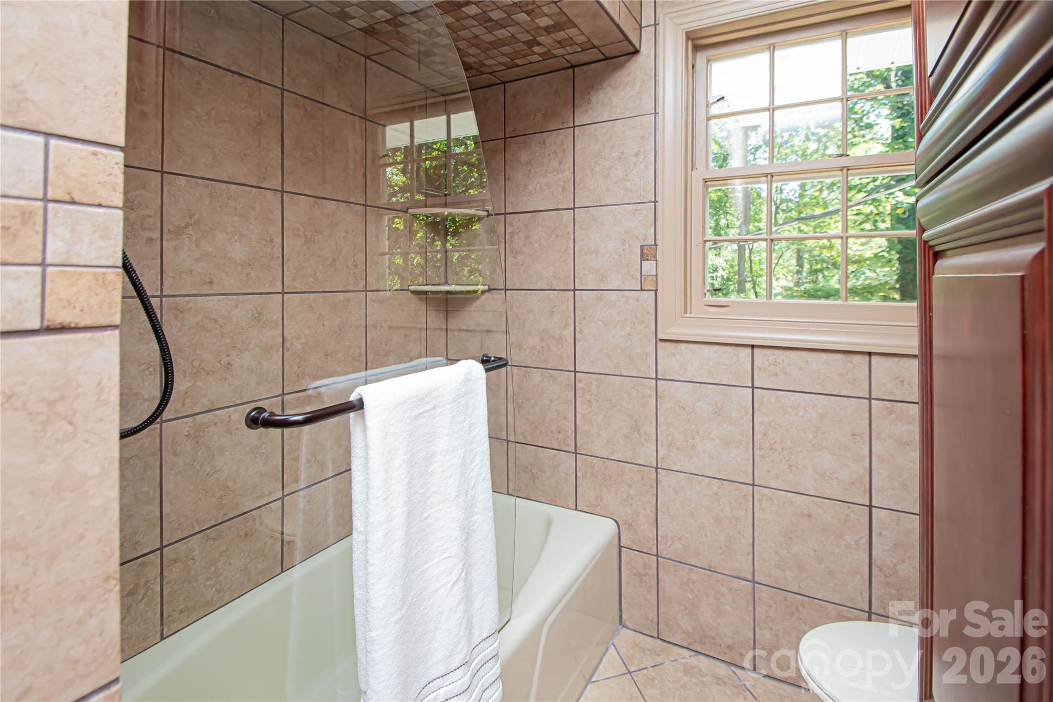 Hall bath on main level was updated a few years ago with granite countertop, all over tile, vanity, faucet, sink and glass shower. - 7400 Oakwood Lane, Charlotte