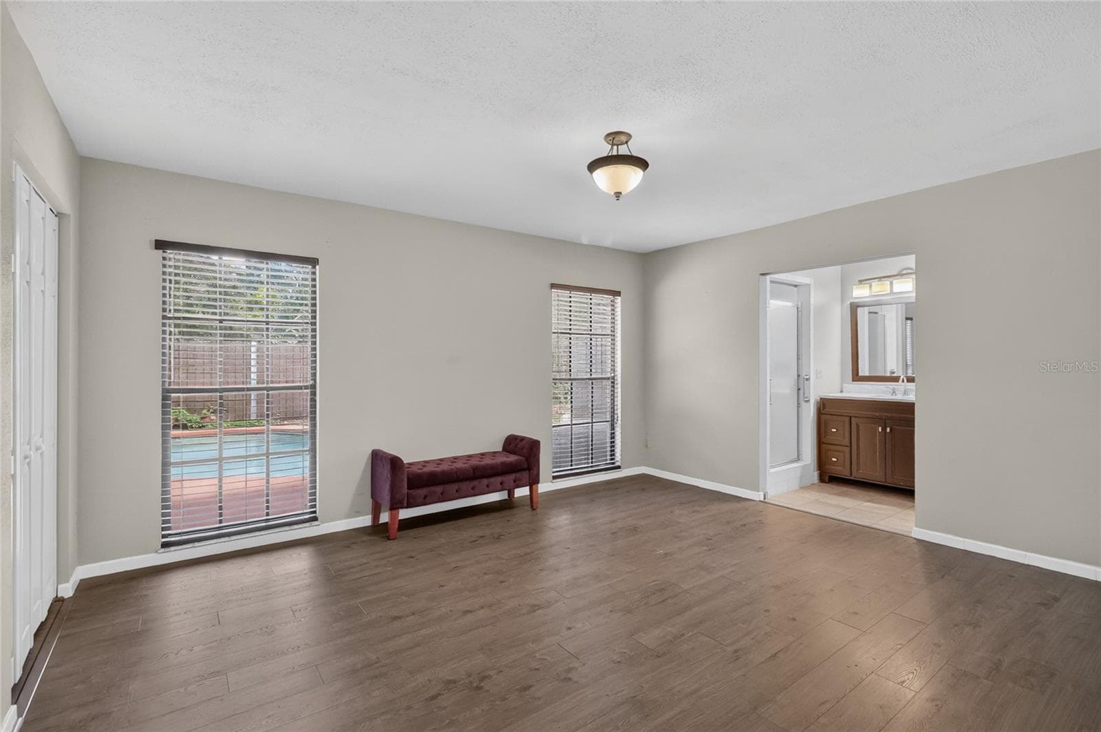 Primary Bedroom is 13' x 15', with laminate flooring, and dual closets. - 3011 LAKE ELLEN DR, TAMPA