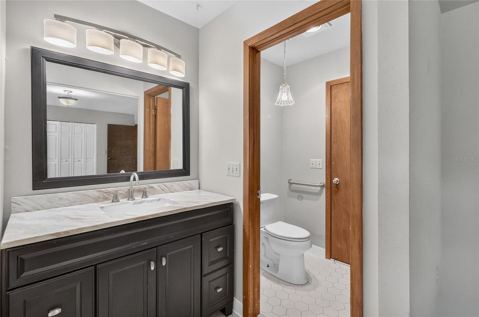 Primary Bedroom features an en suite bathroom, with vanity, separate toilet area, and glass-enclosed shower. - 3011 LAKE ELLEN DR, TAMPA
