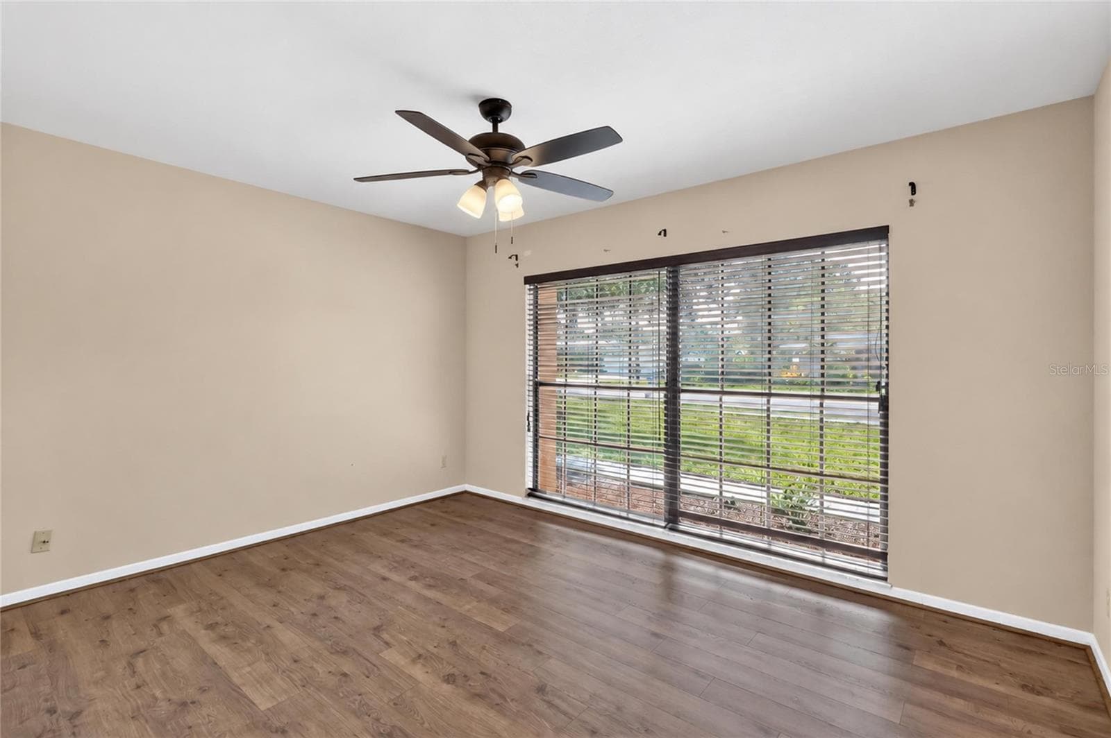Bedroom 2 is 13' x 10.9', with laminate flooring, dual closets, and a ceiling fan. - 3011 LAKE ELLEN DR, TAMPA
