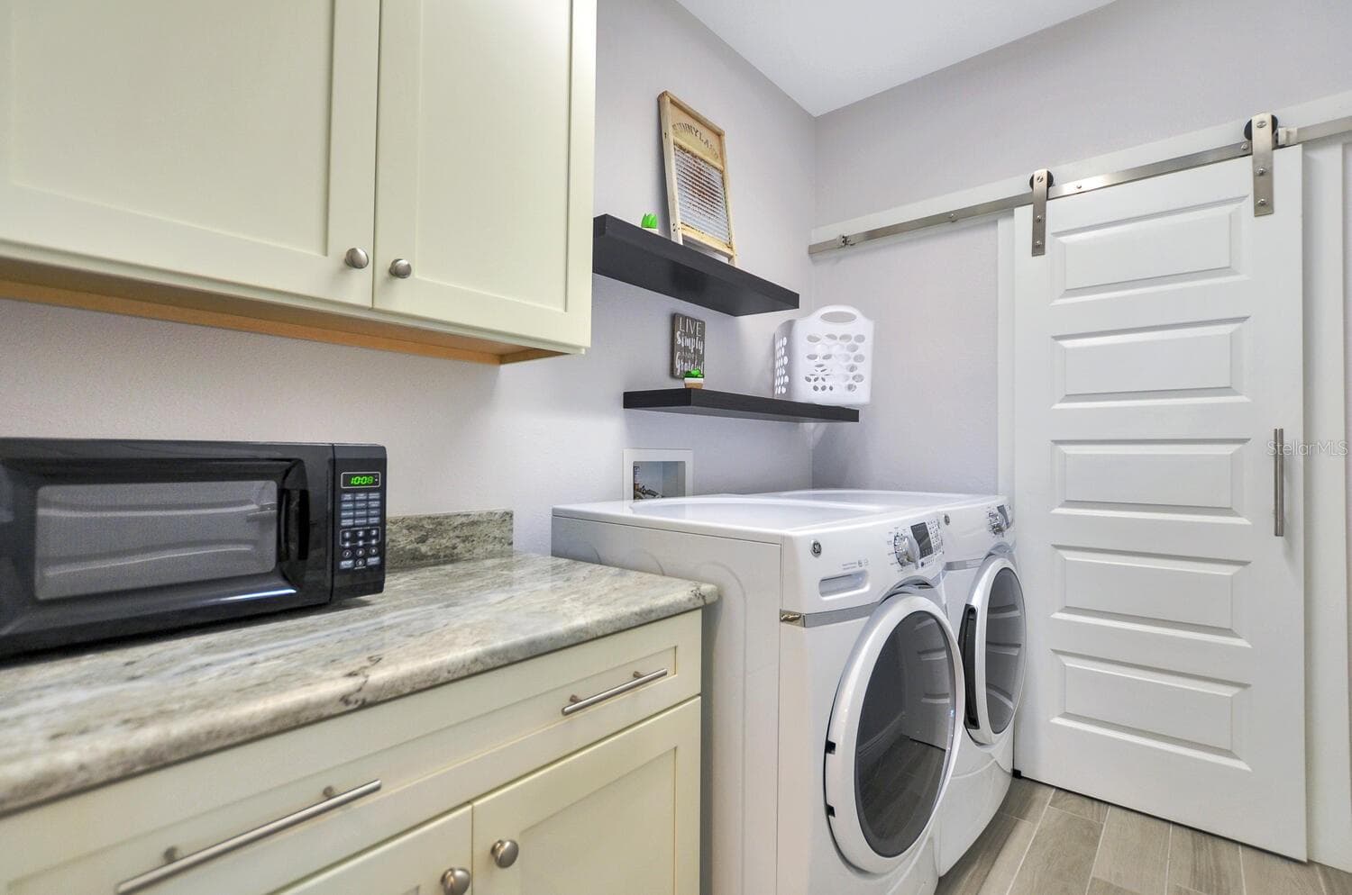 laundry room with barn door to storage room - 7210 S MASCOTTE ST, TAMPA