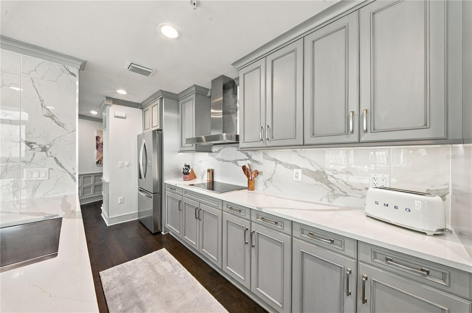 Kitchen | Quartzite countertops and full-height slab backsplash pair with streamlined cabinetry - 260 S OSCEOLA AVE #1406, ORLANDO