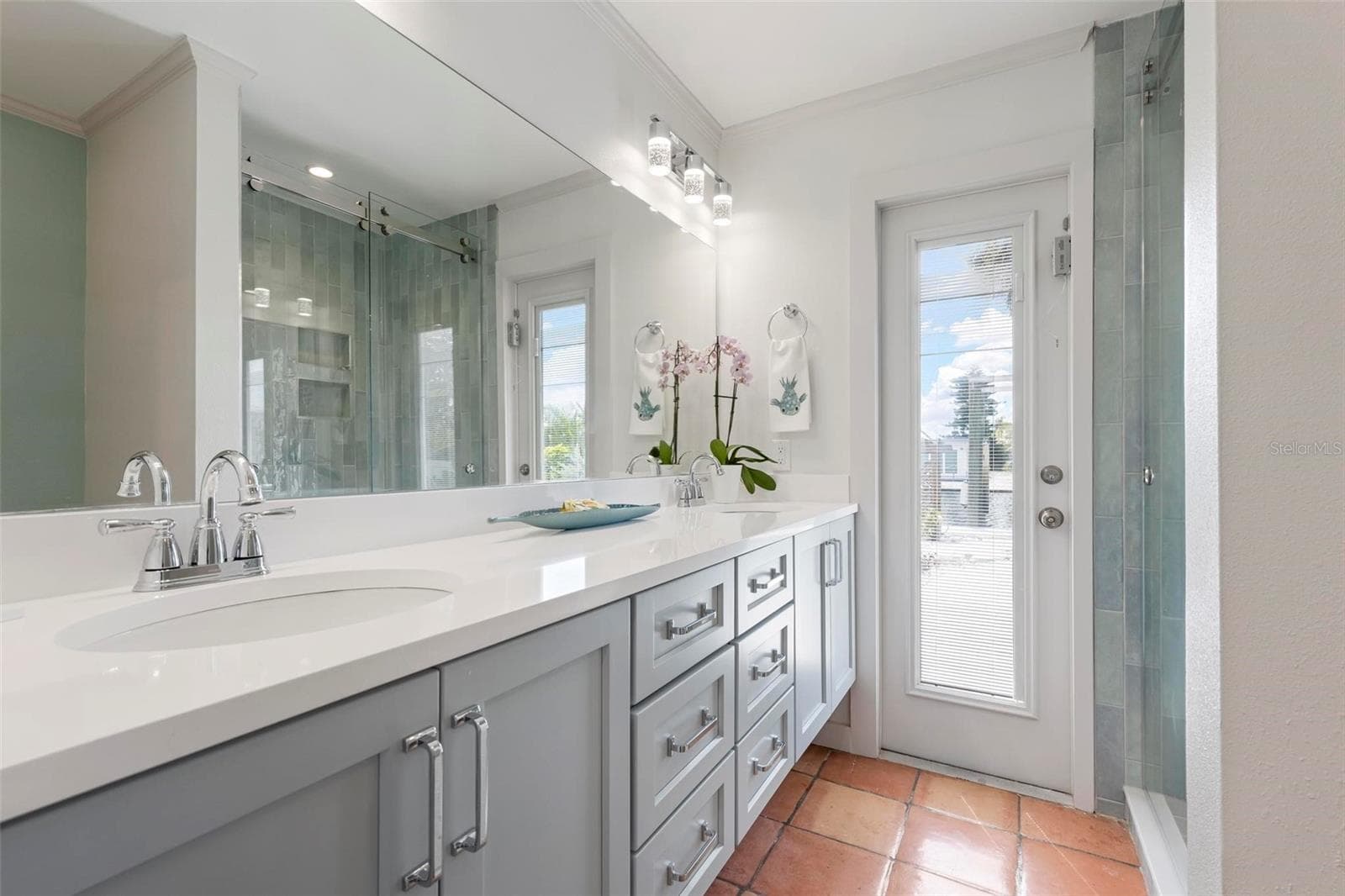 Beautifully remodeled Primary Bathroom with dual vanities, a walkin shower and access to the outdoor pool and dock. - 503 65TH ST, HOLMES BEACH